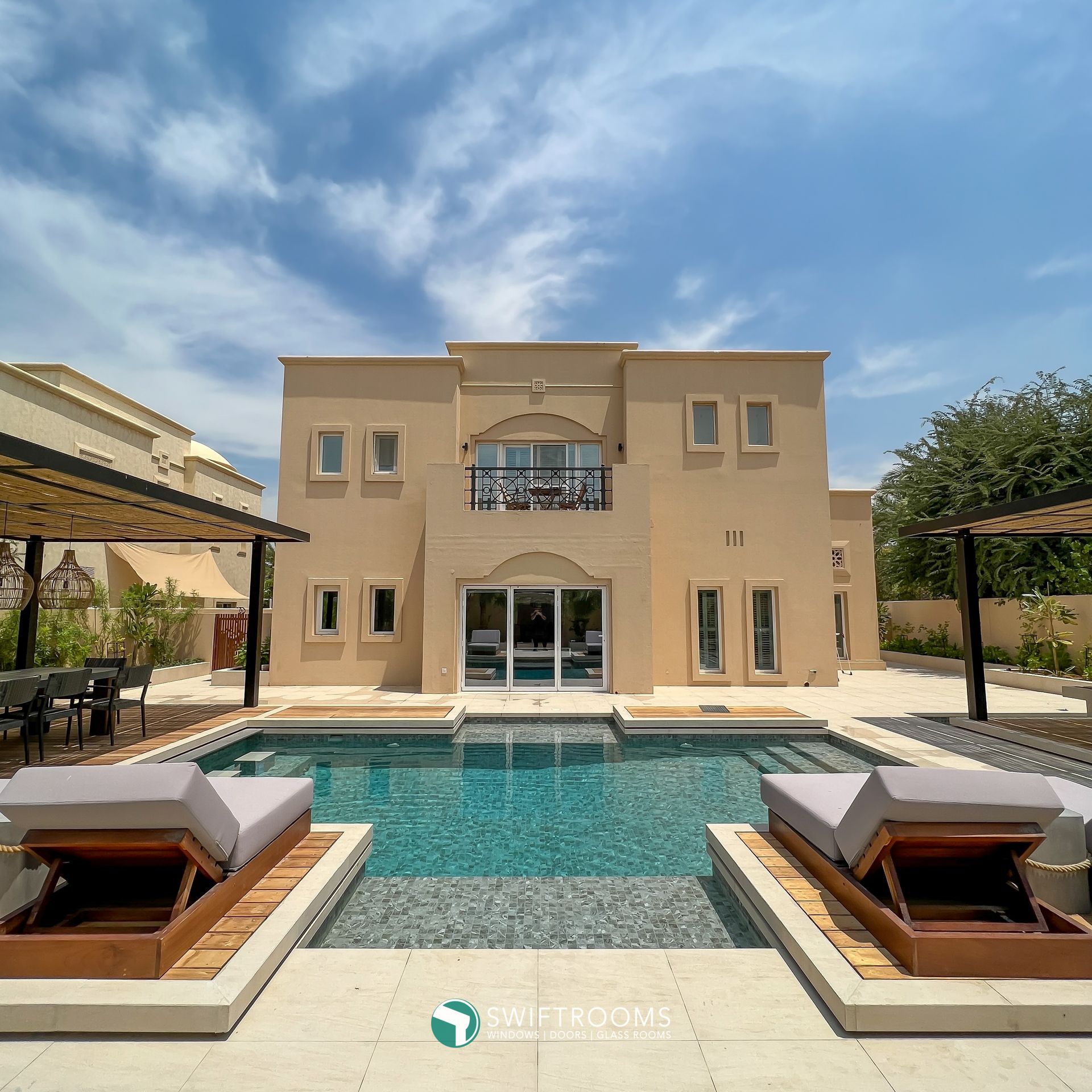 A large house with a large swimming pool in front of it