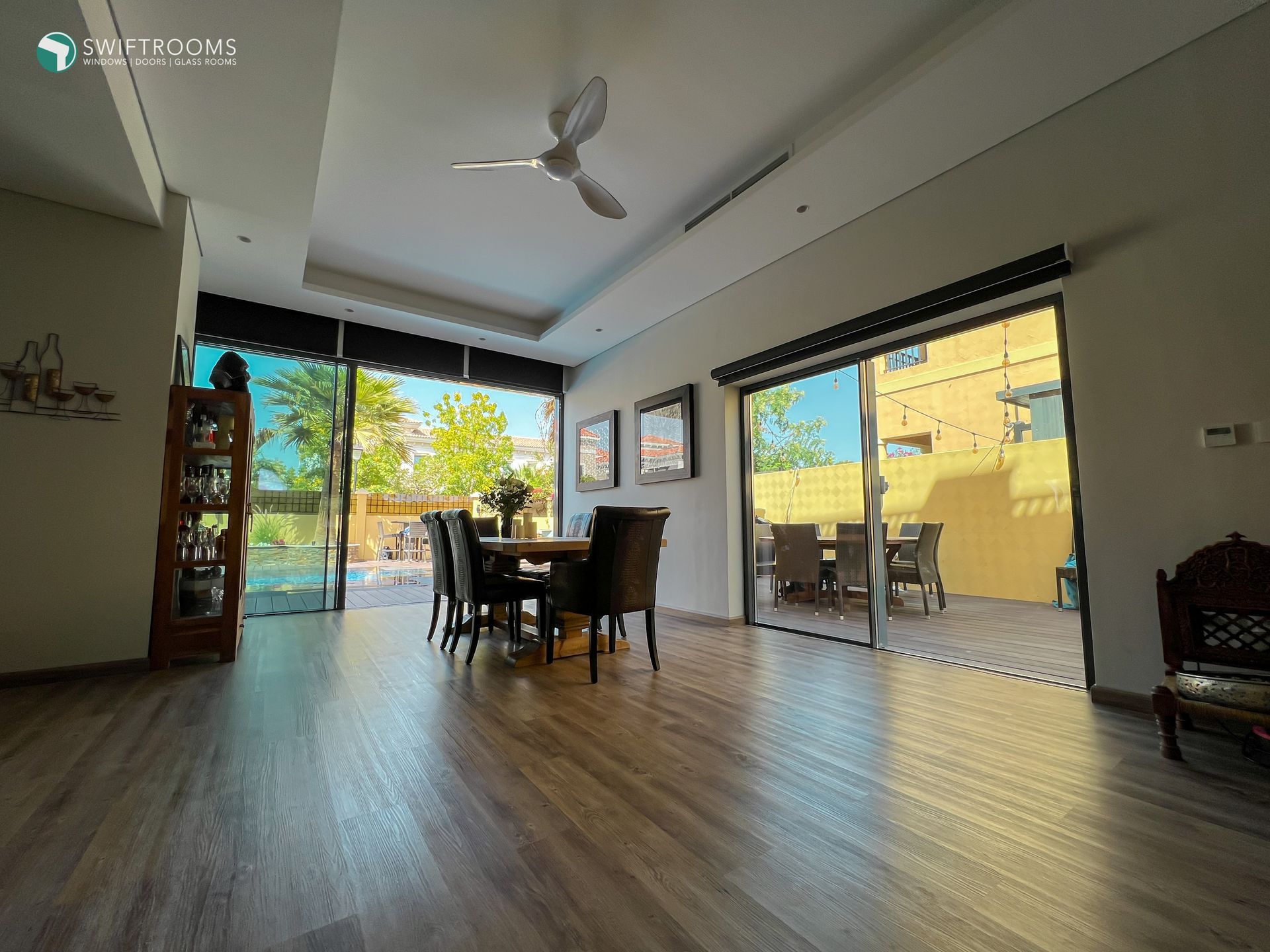 A dining room with a table and chairs and a ceiling fan.