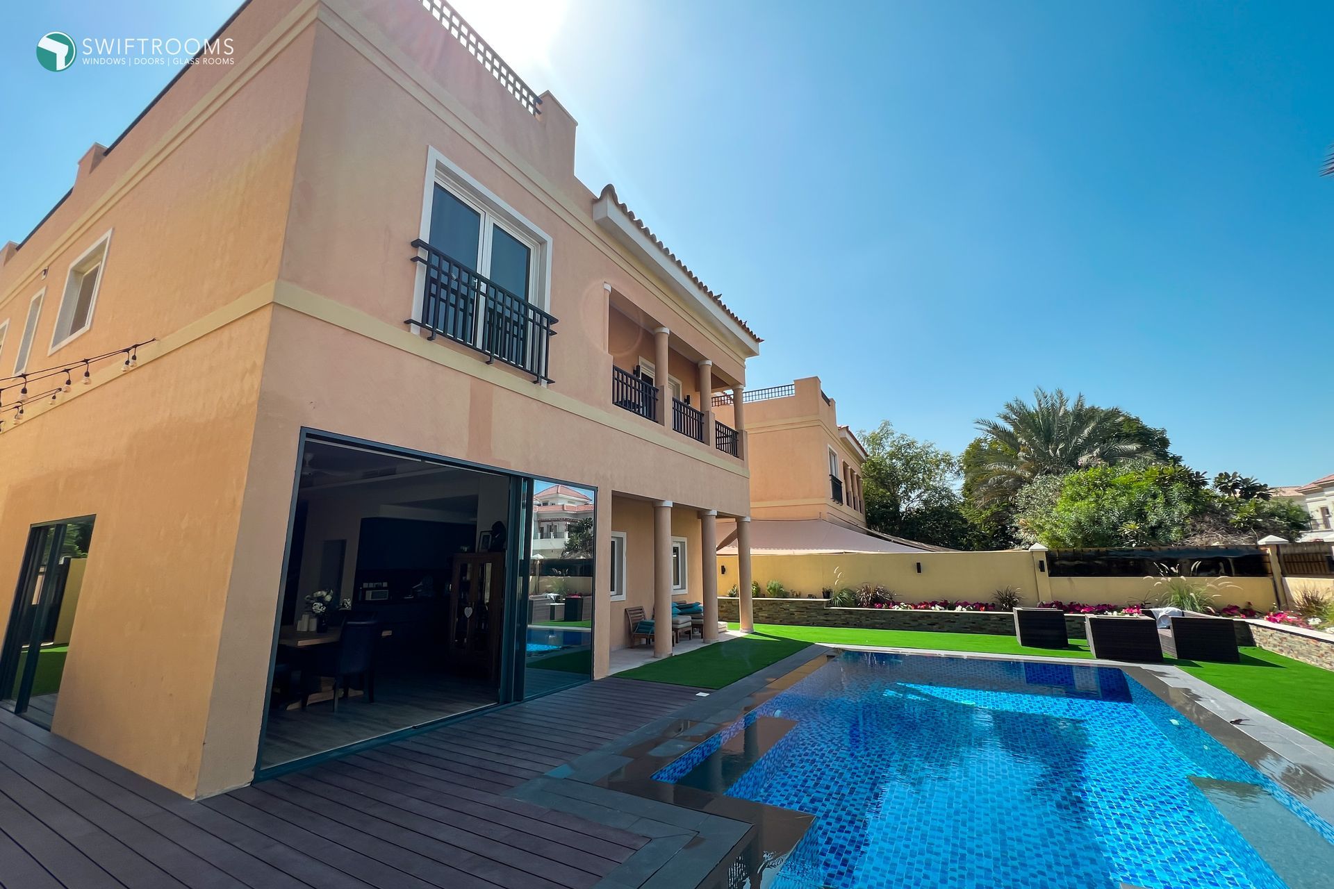 A large house with a swimming pool in front of it