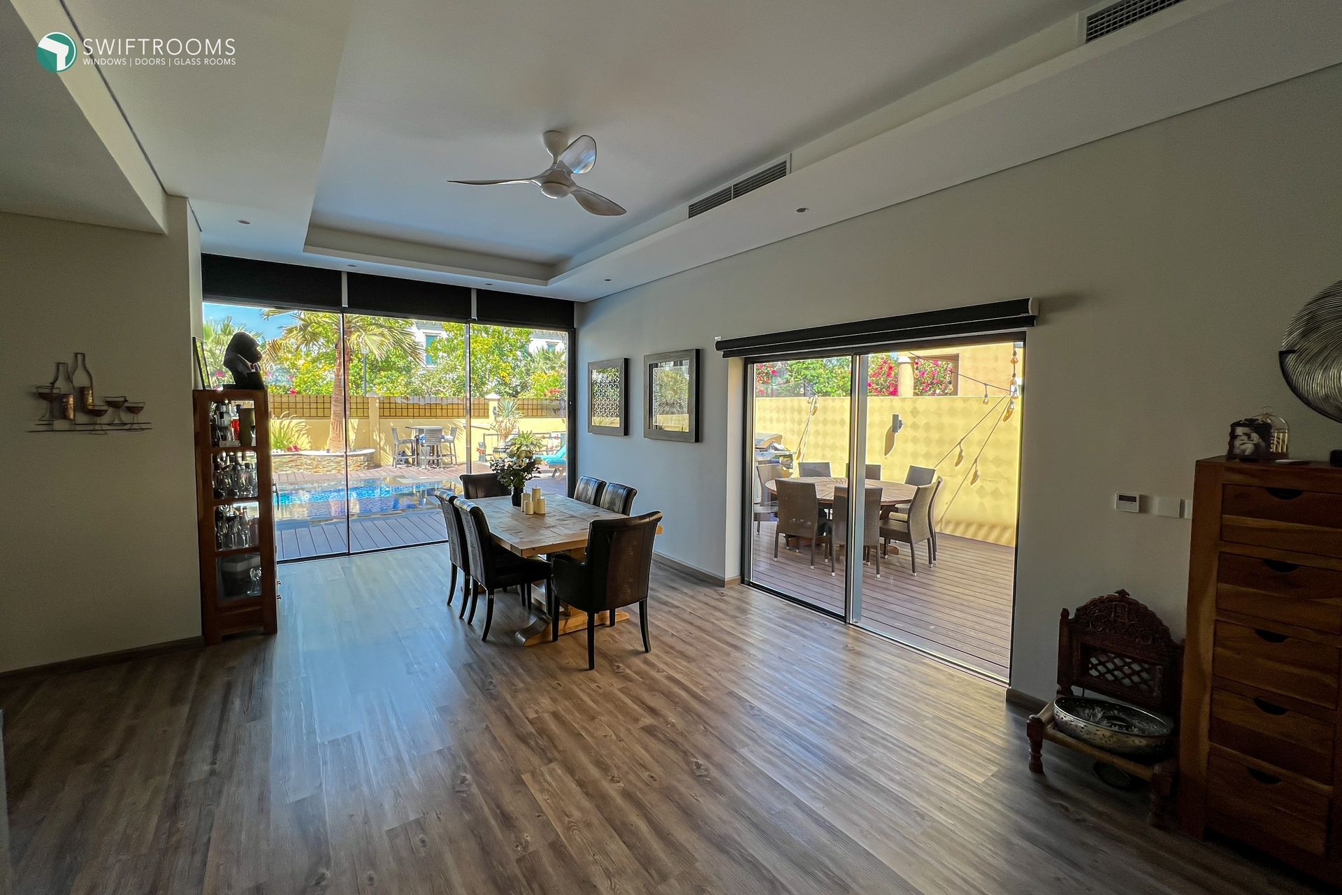 A living room with a table and chairs and a ceiling fan.