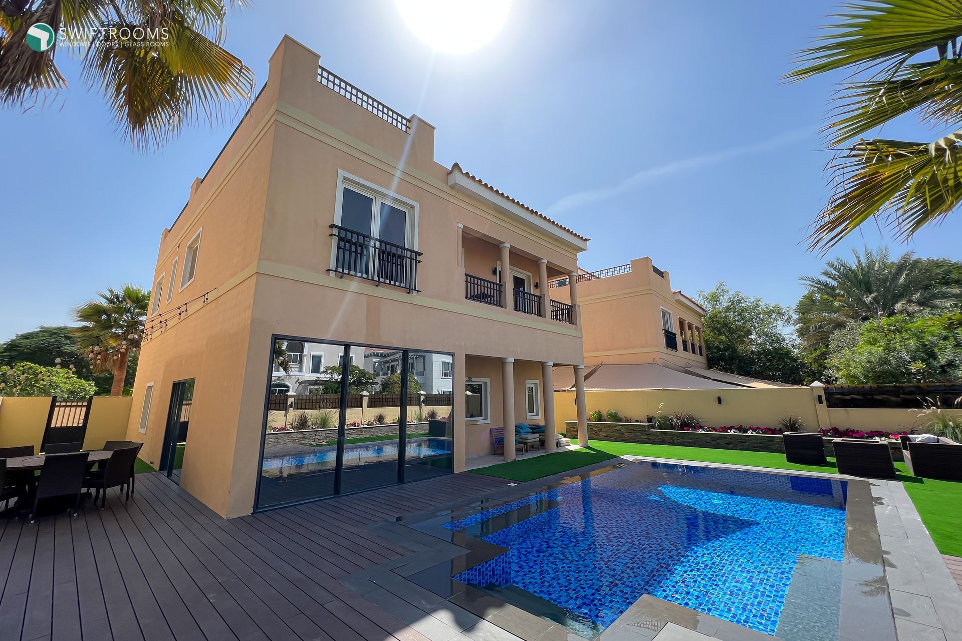 A large house with a large swimming pool in front of it.