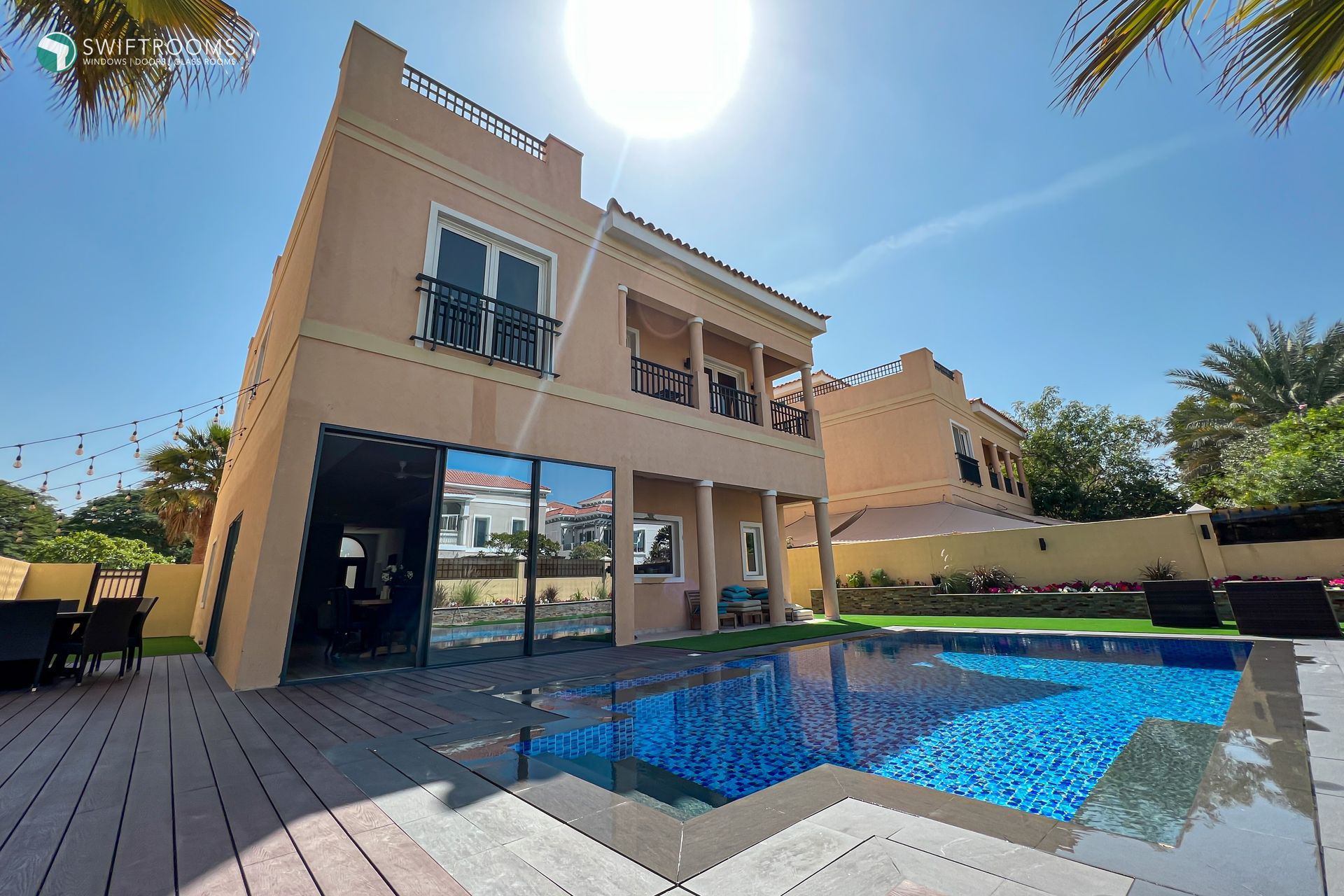 A large house with a swimming pool in front of it.