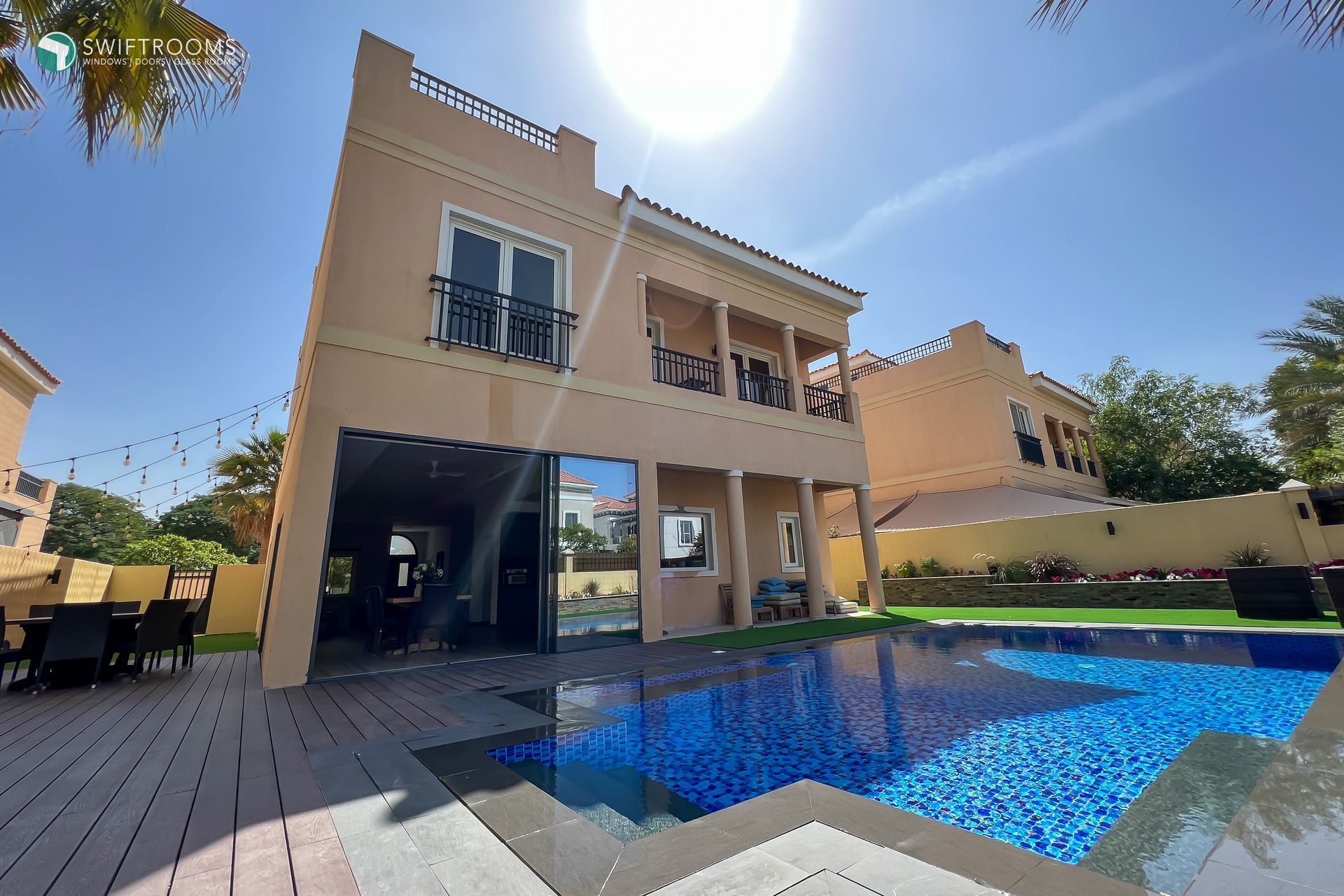 A large house with a swimming pool in front of it