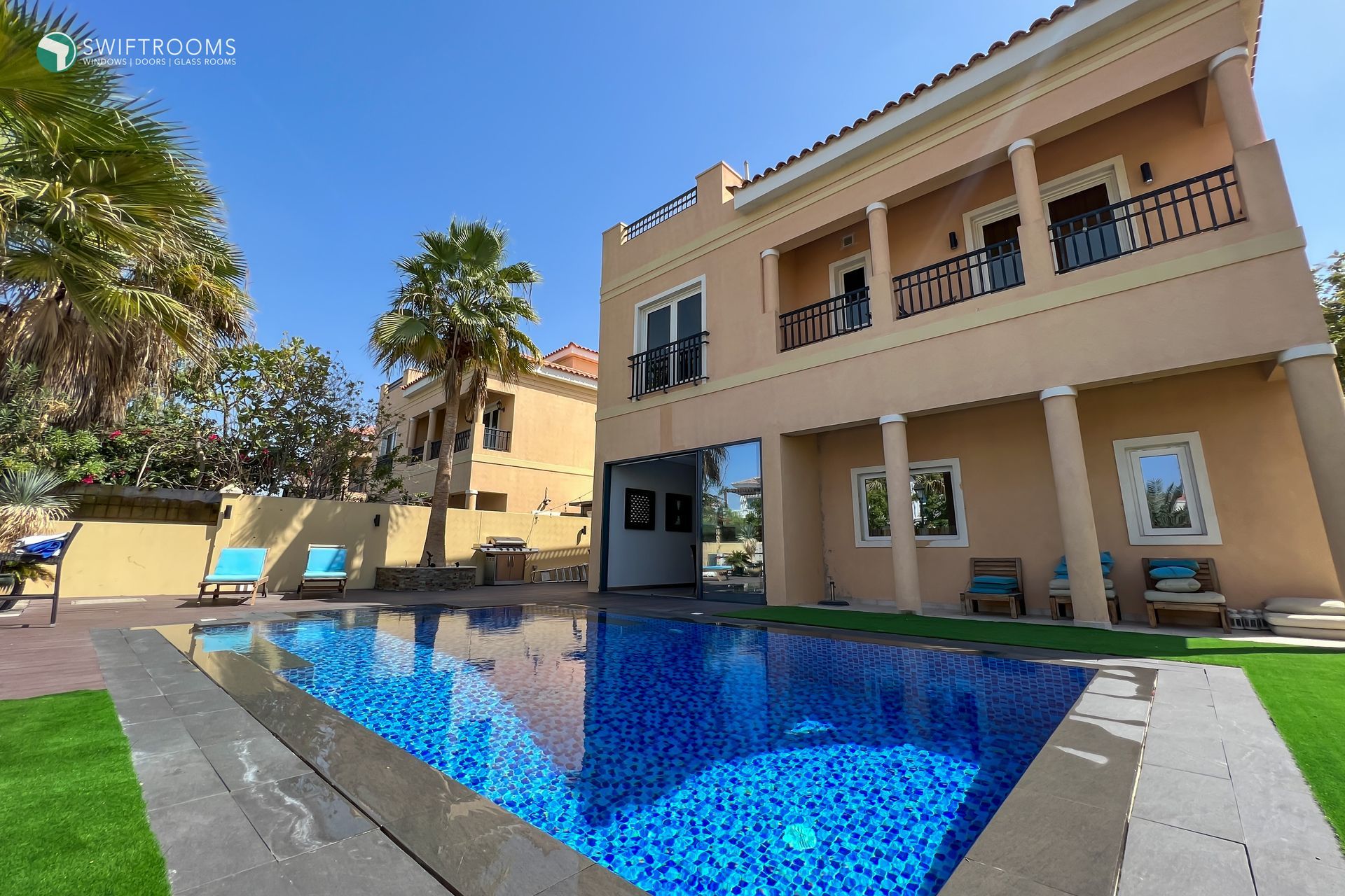 A large house with a large swimming pool in front of it
