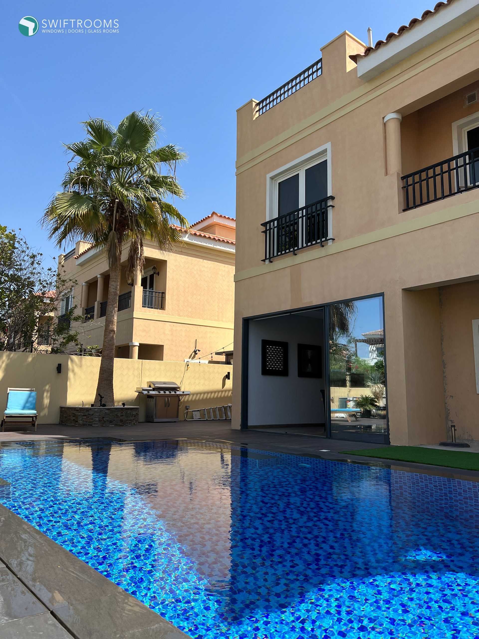 A large house with a swimming pool in front of it