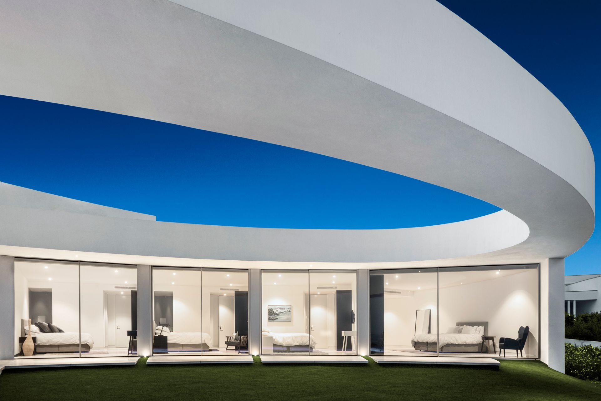 A white house with a curved roof and lots of windows