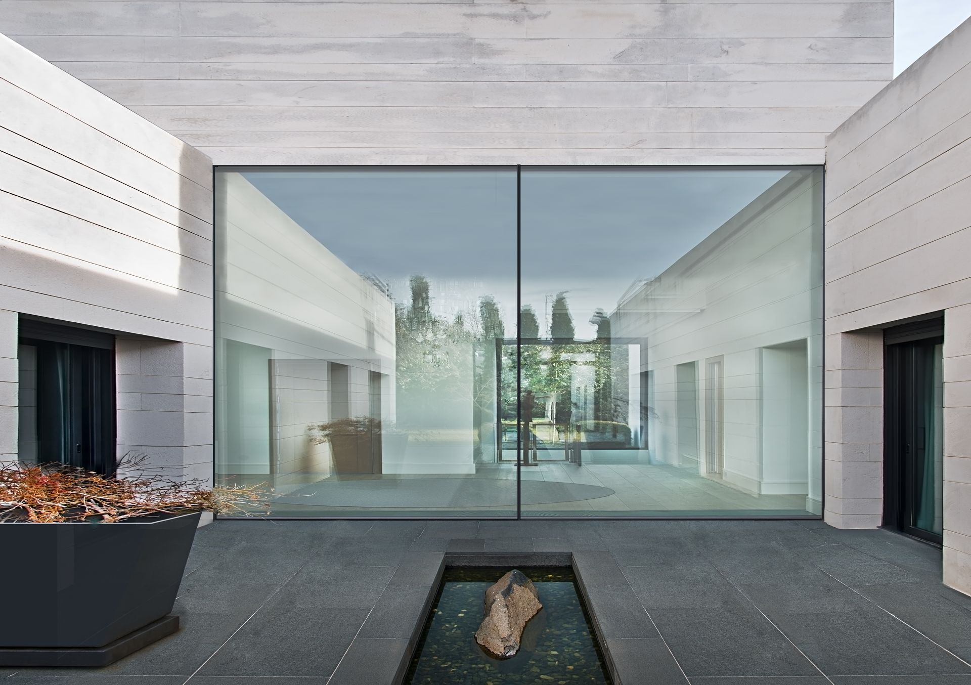 A building with a large glass window and a fountain in front of it