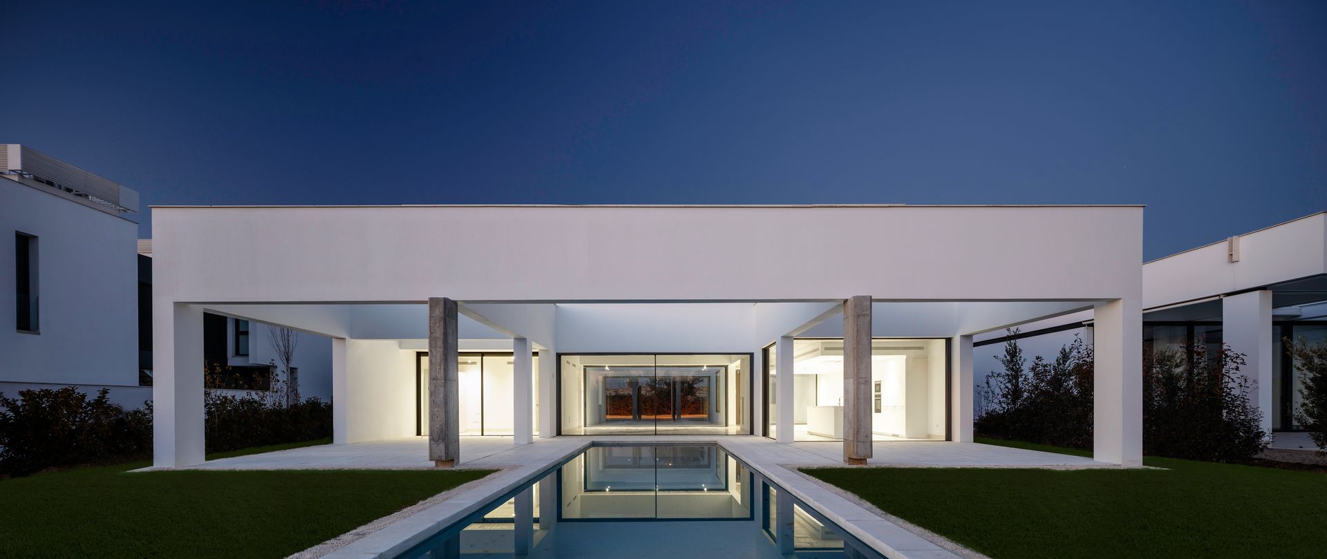 A white house with a swimming pool in front of it