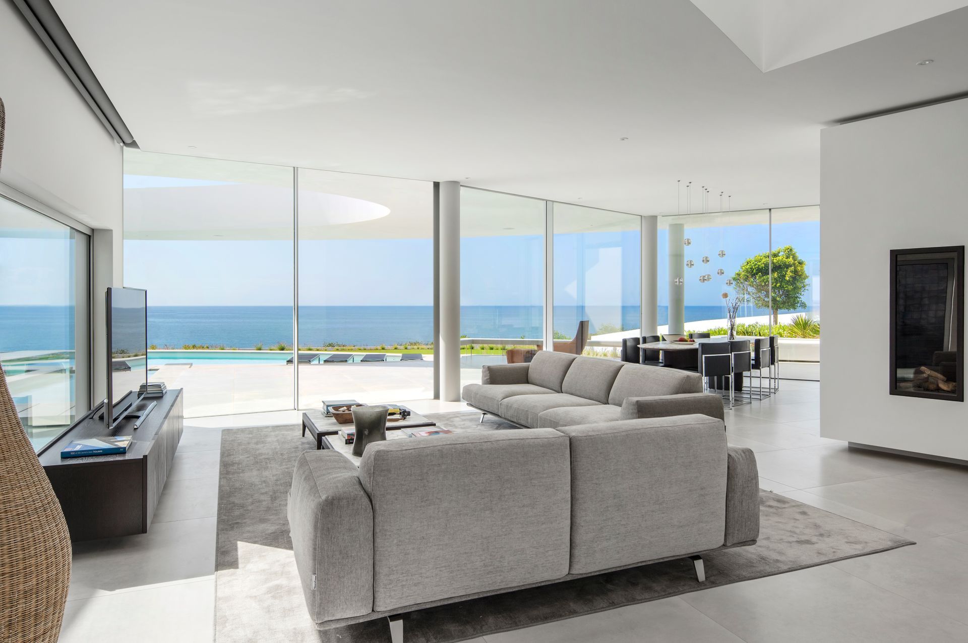 A living room with a couch and a television with a view of the ocean