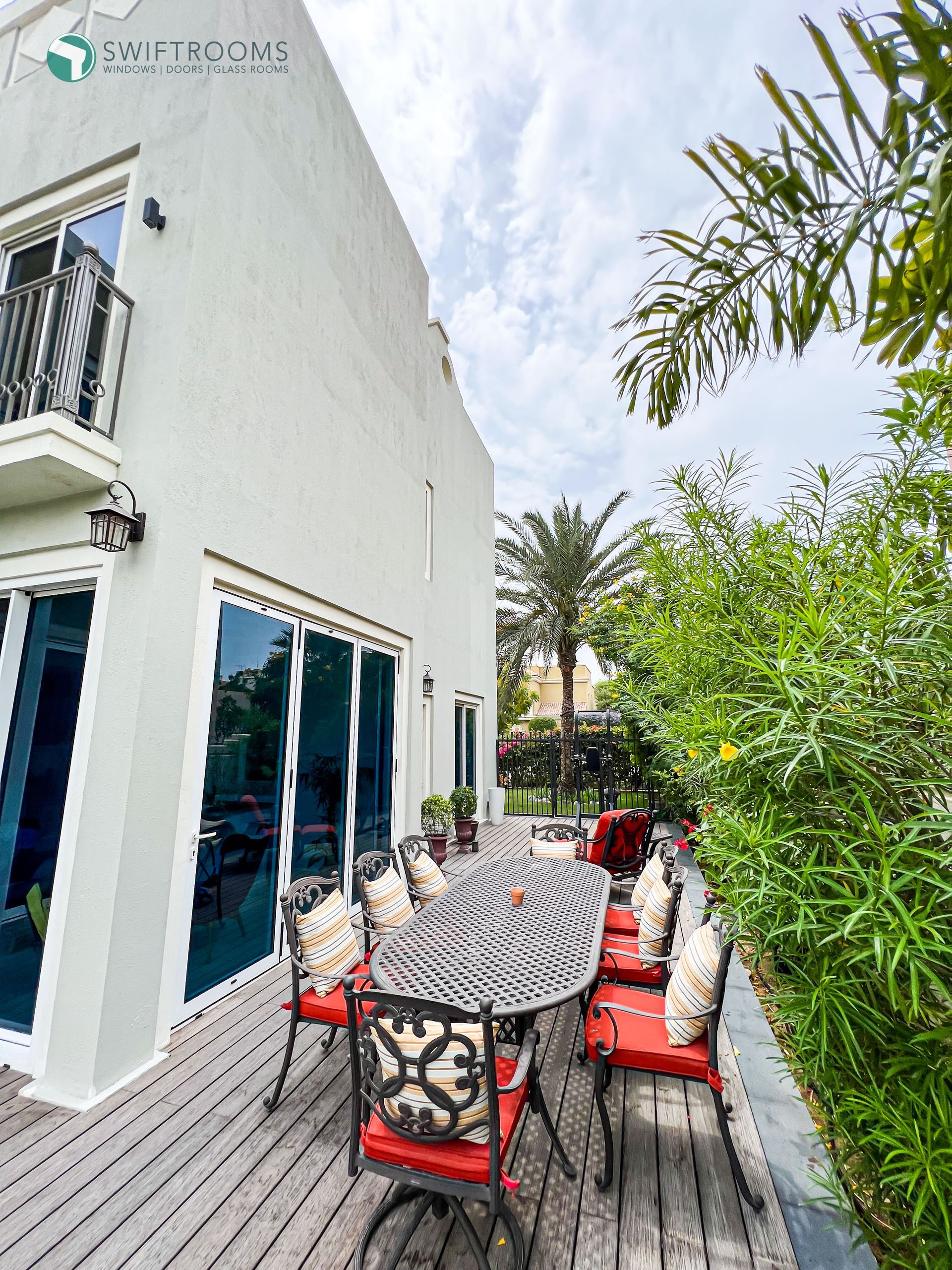 There is a table and chairs on the deck of a house.