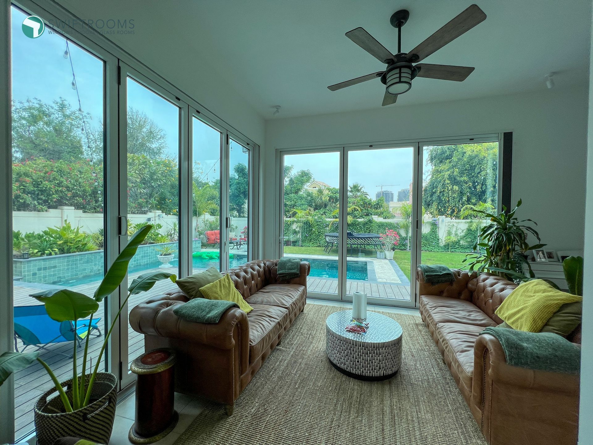 A living room with two couches , a coffee table and a ceiling fan.