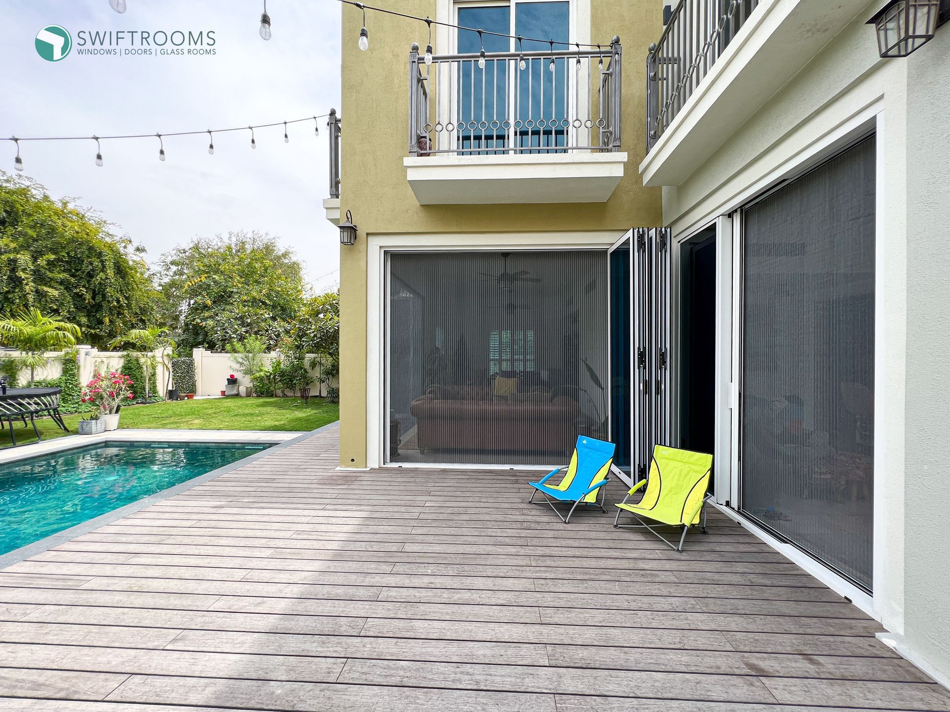 There is a swimming pool in the backyard of a house.