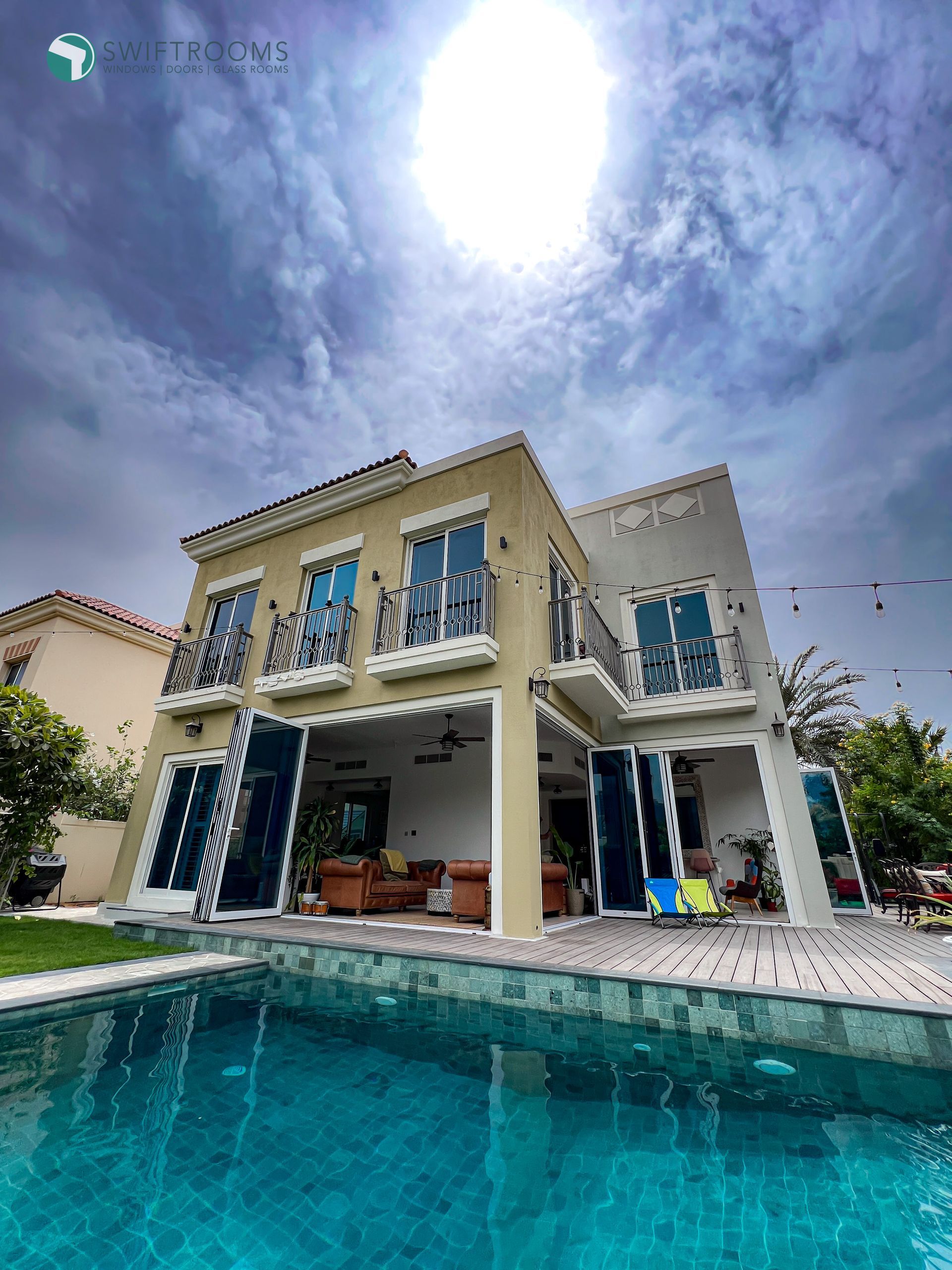 A large house with a swimming pool in front of it.