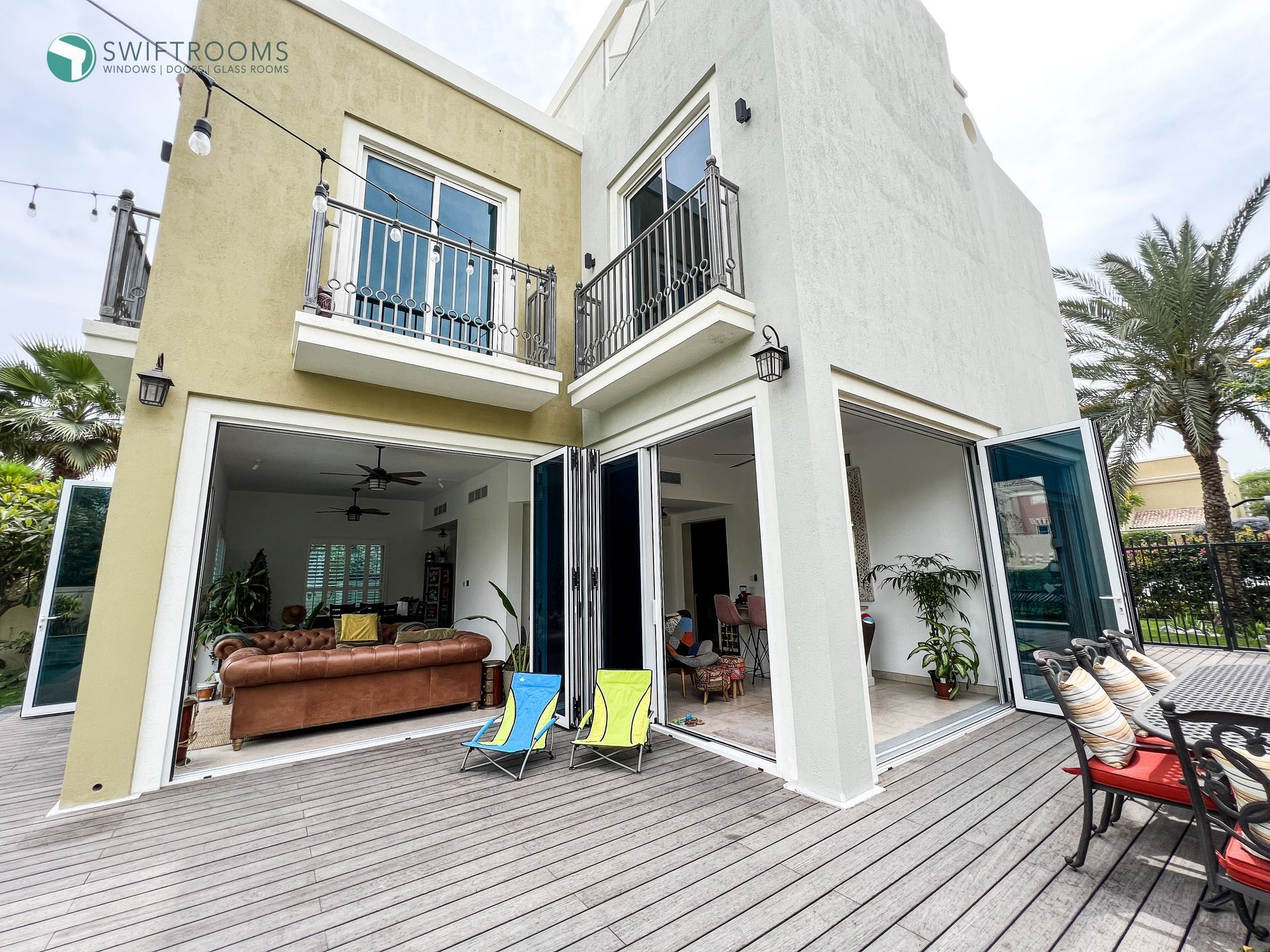 The back of a house with a large deck and sliding glass doors.