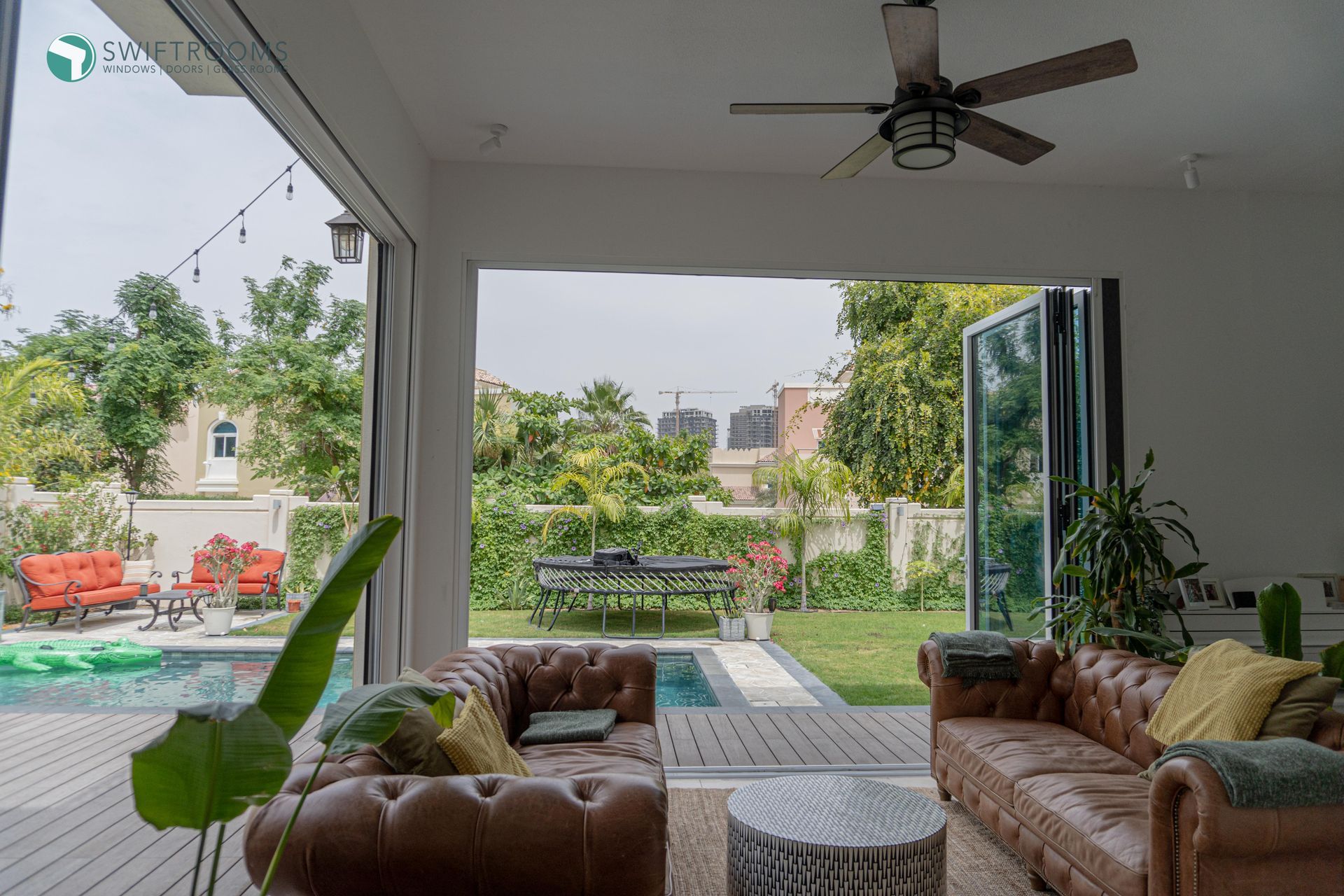 A living room with a couch , table , and ceiling fan.