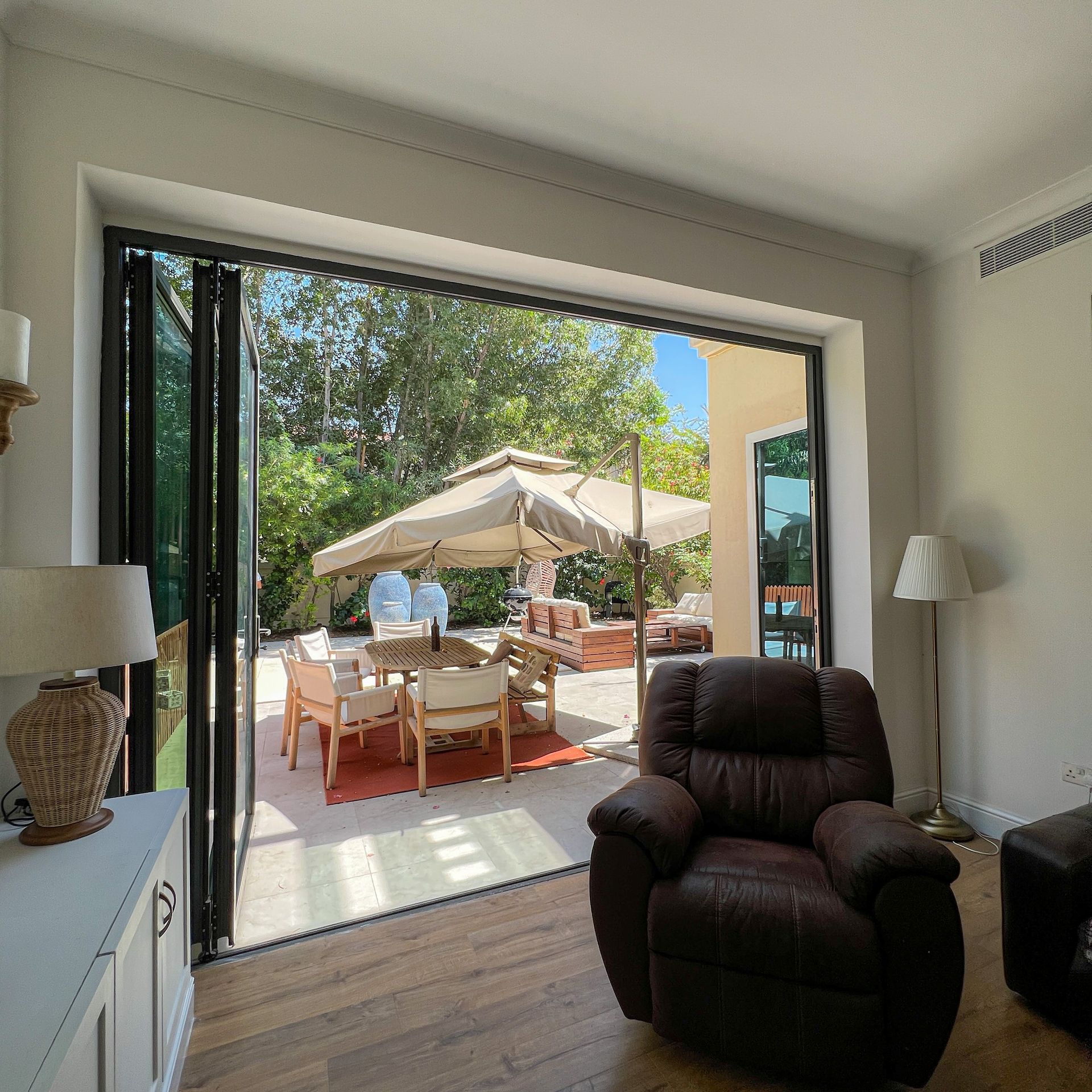 A living room with a brown recliner and a table and chairs