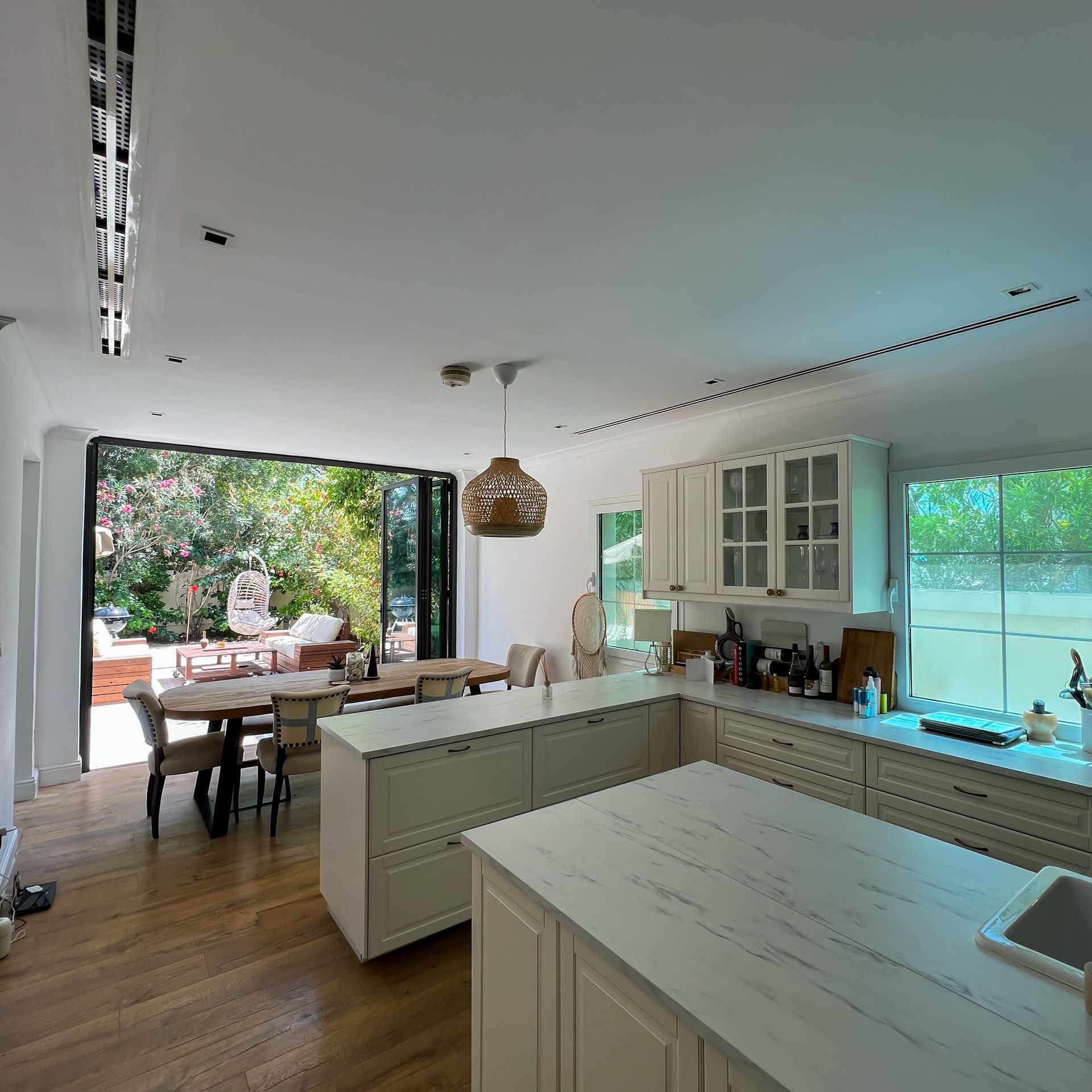 A kitchen with white cabinets and a large island in the middle