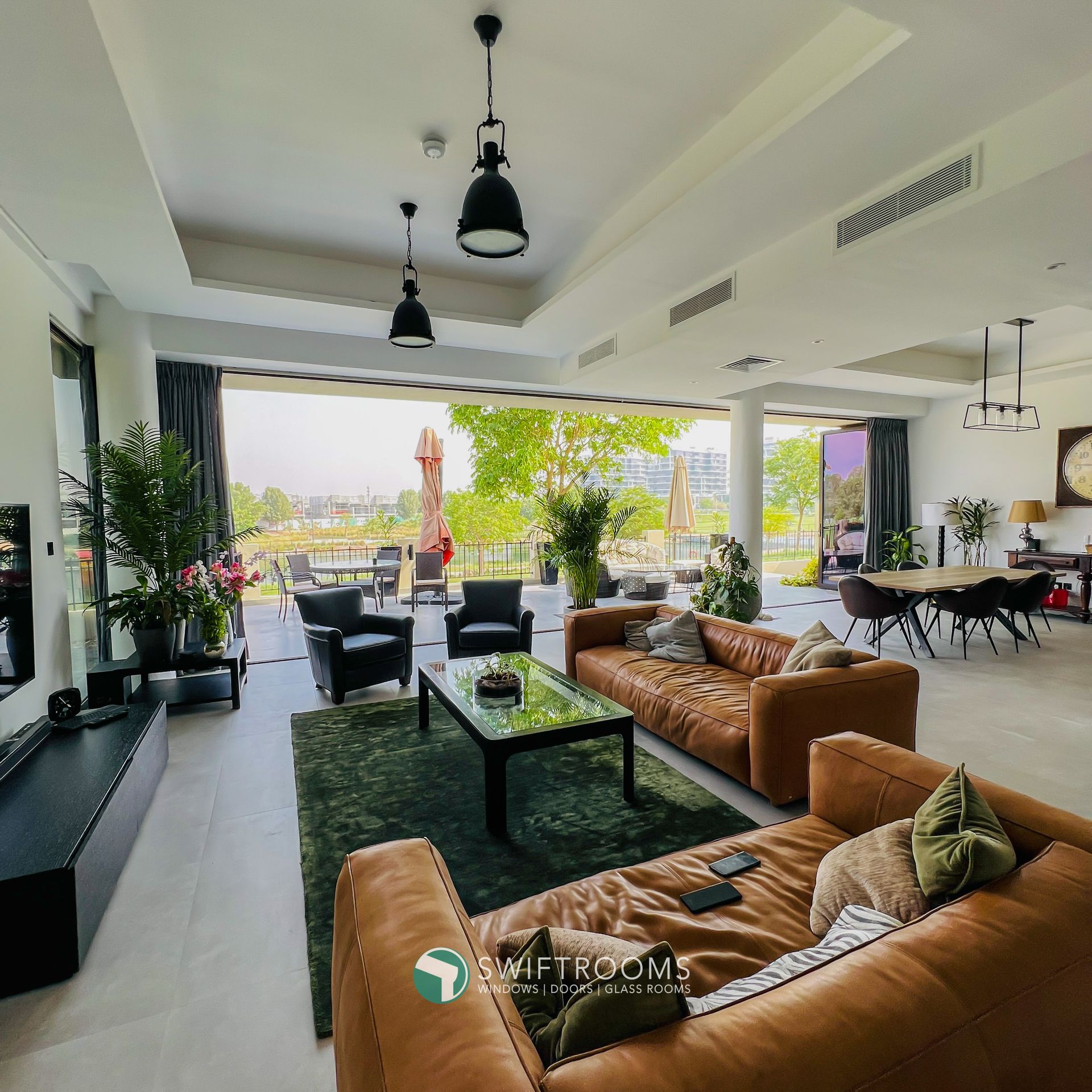 A living room with a brown couch and a green rug