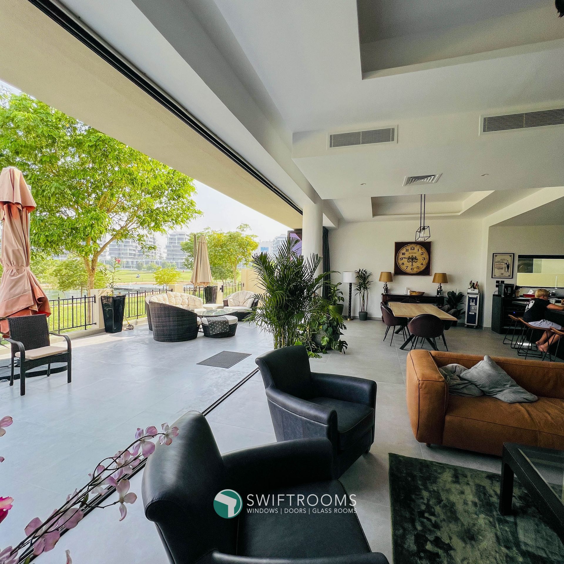 A living room with furniture and a clock on the wall