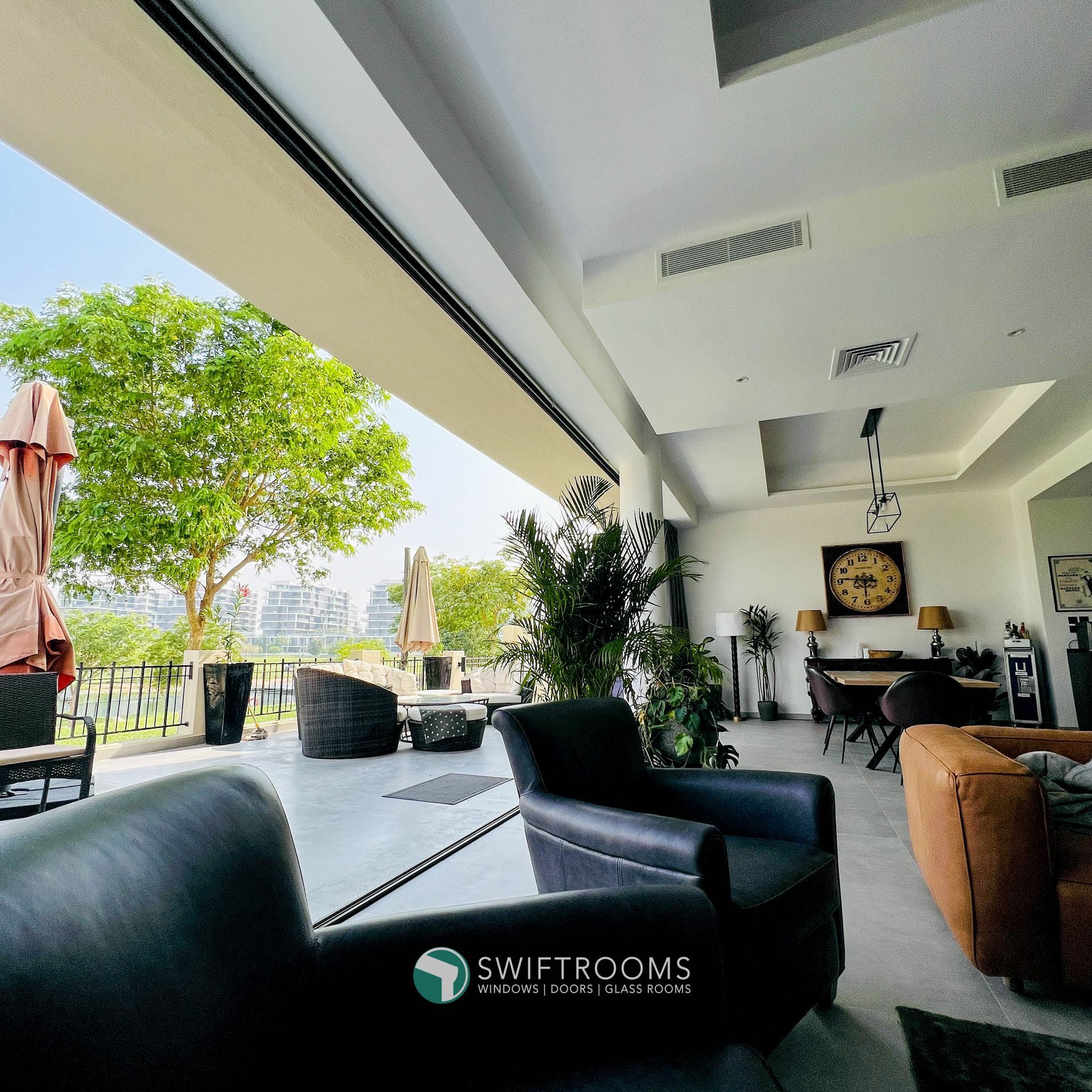 A living room with a clock on the wall that says swift rooms