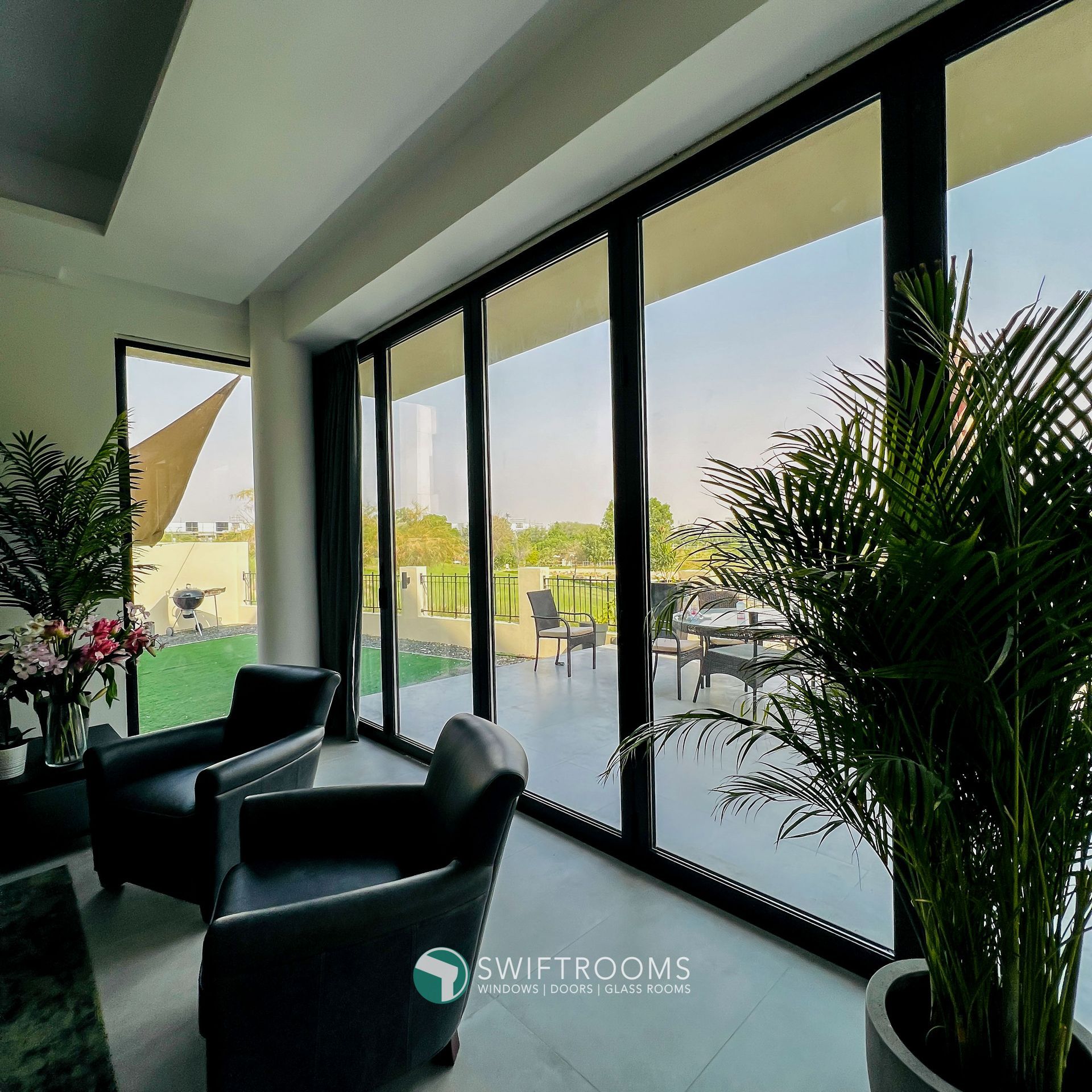 A living room with a lot of windows and chairs