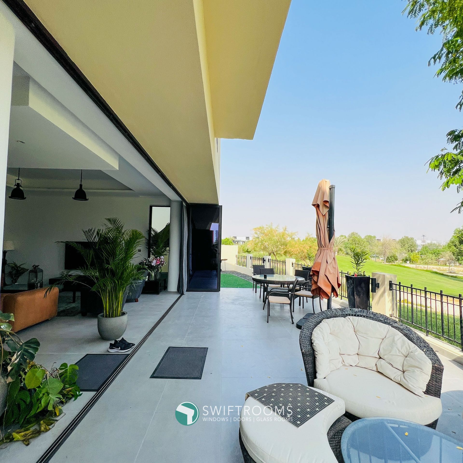 A patio with a couch and umbrella and a sign that says swift homes
