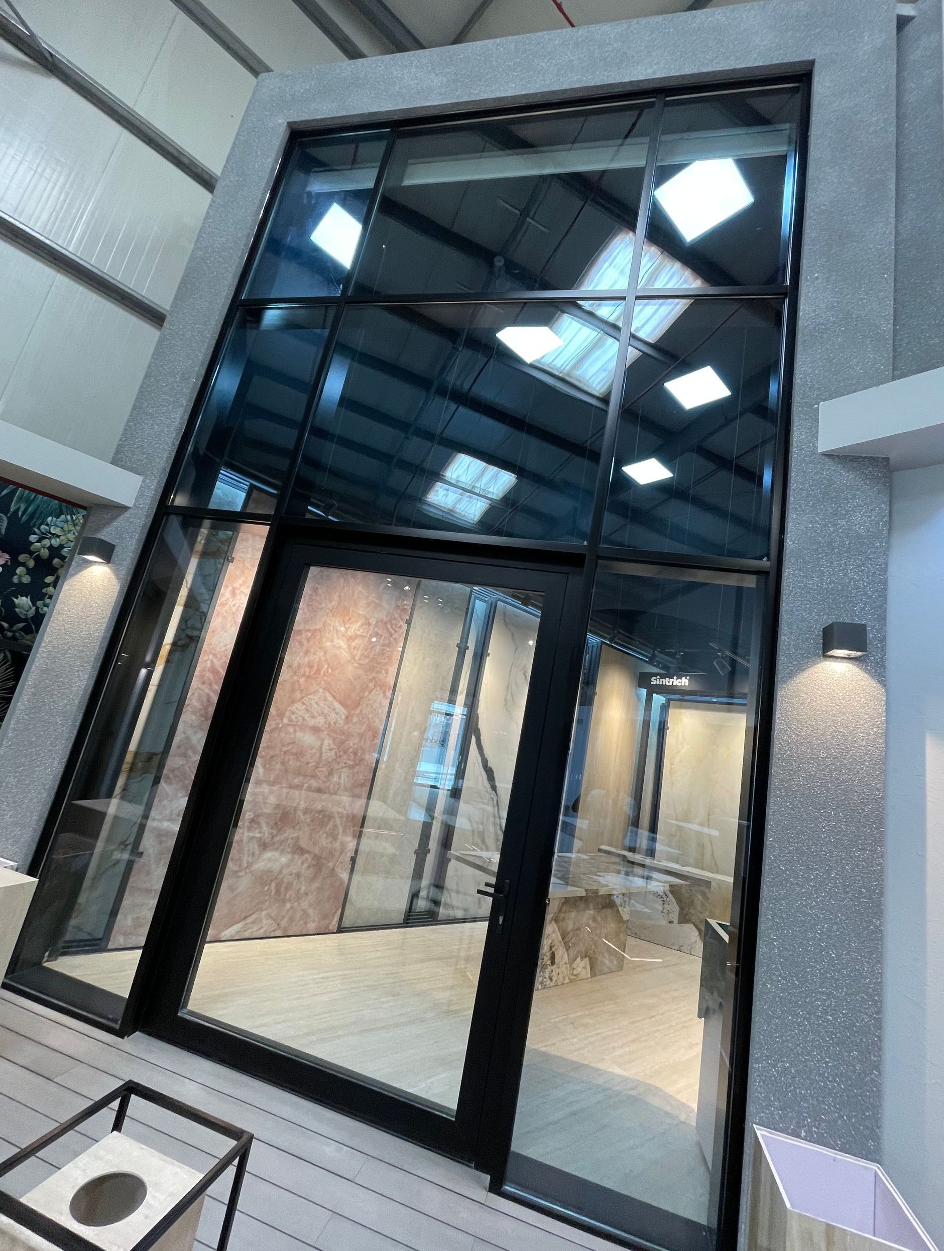 A room with a lot of windows and a dog in the background.