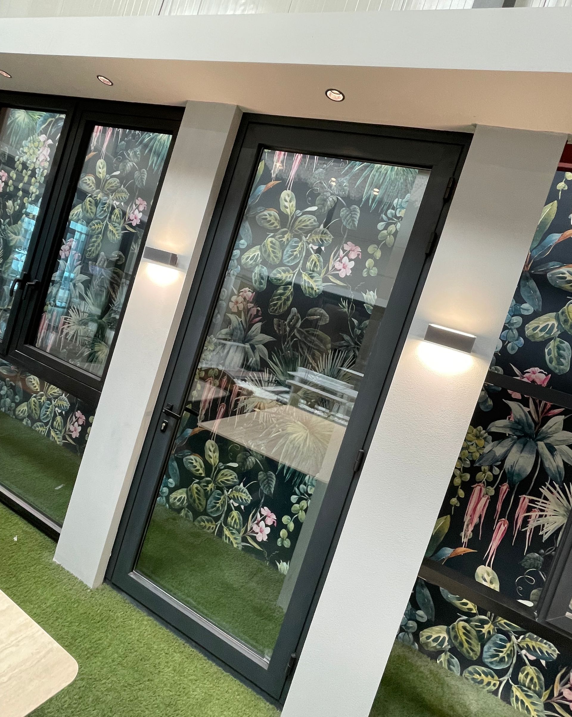 A room with a lot of windows and a floral wallpaper on the wall.