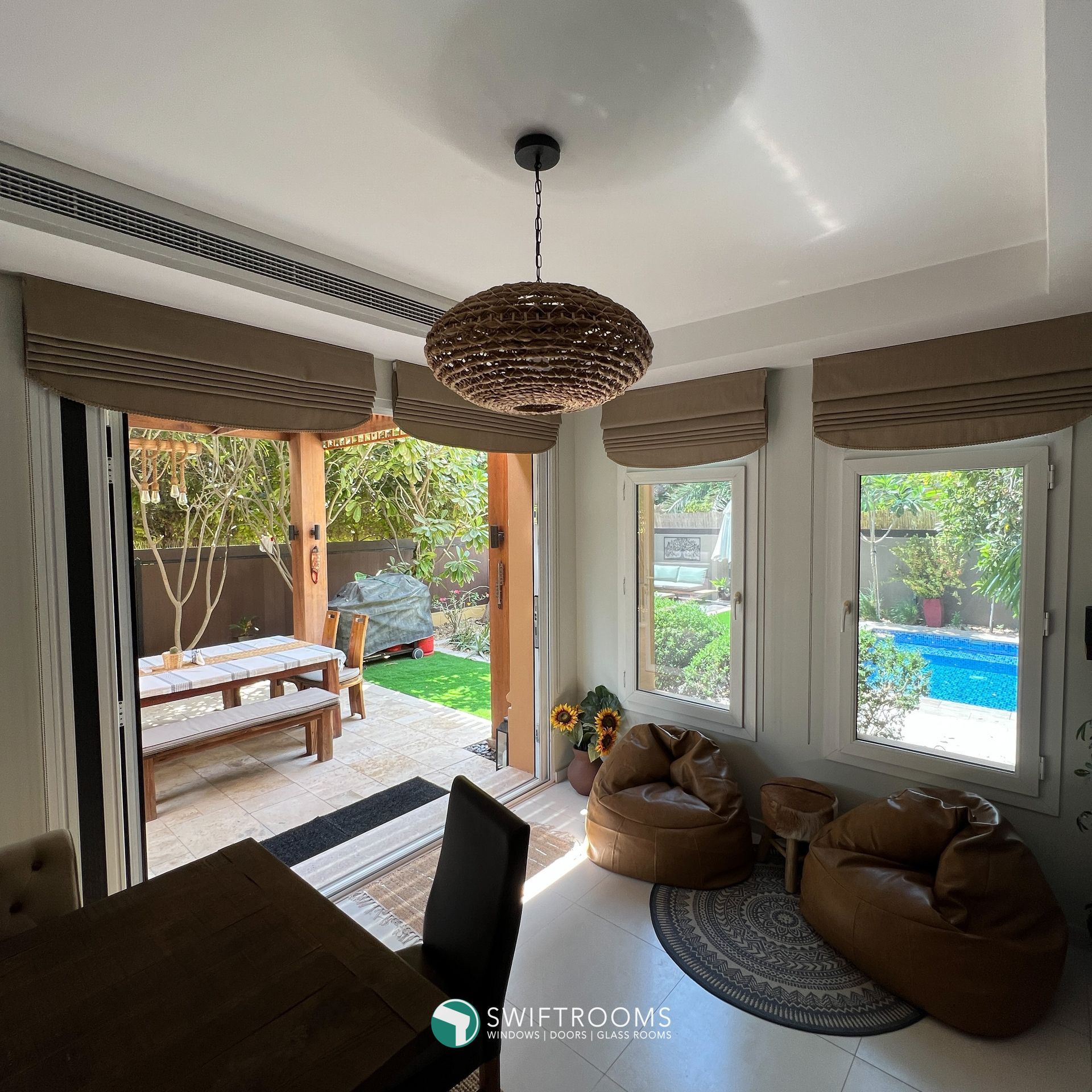 A living room with a table and chairs and a ceiling light