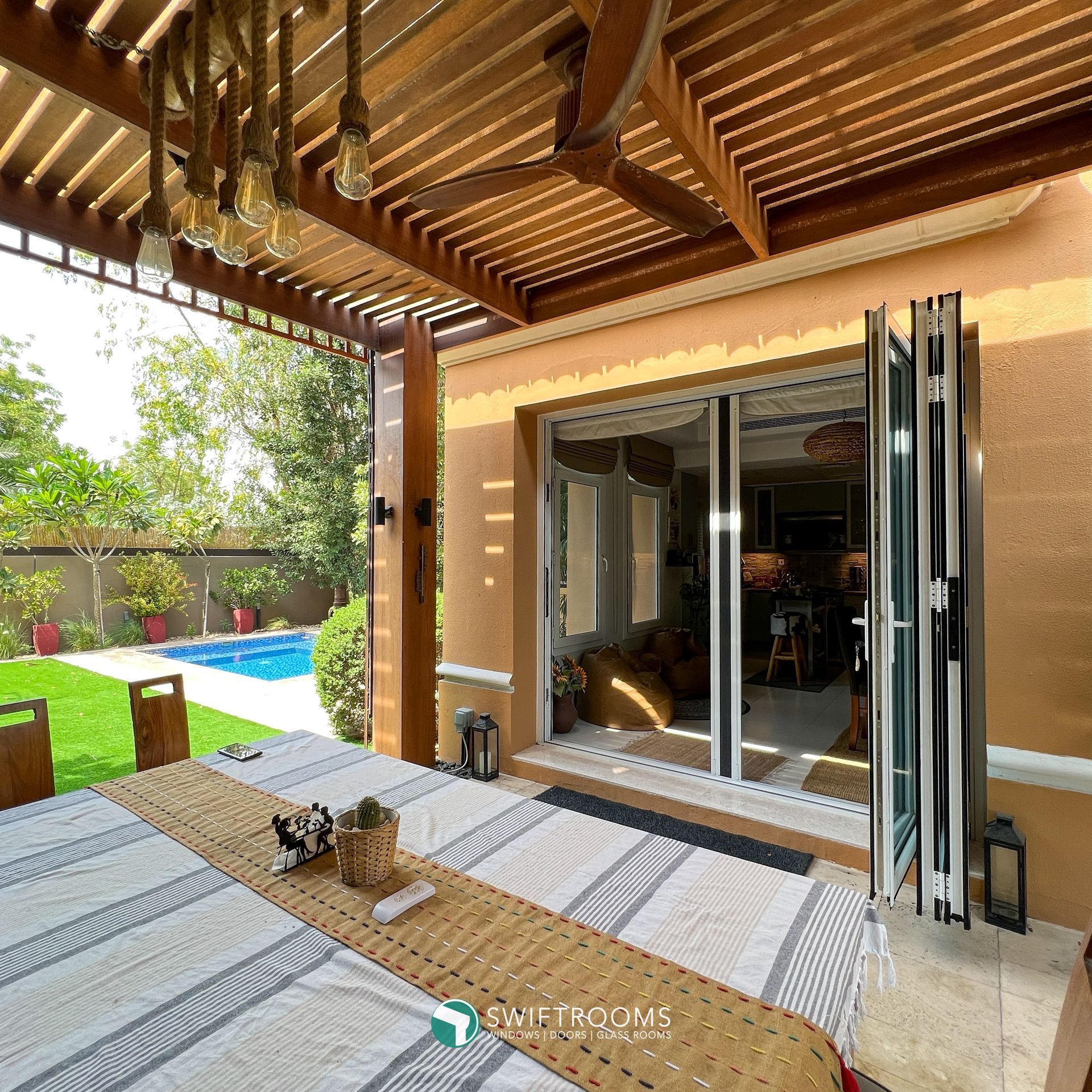 A patio with a table and chairs under a wooden pergola