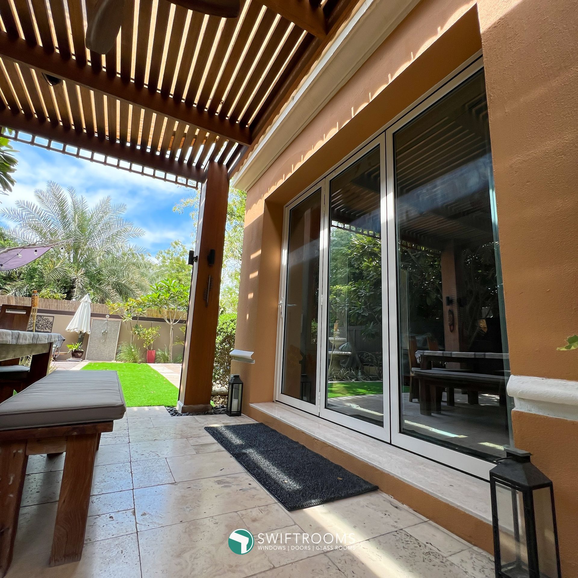 A patio with a pergola and sliding glass doors