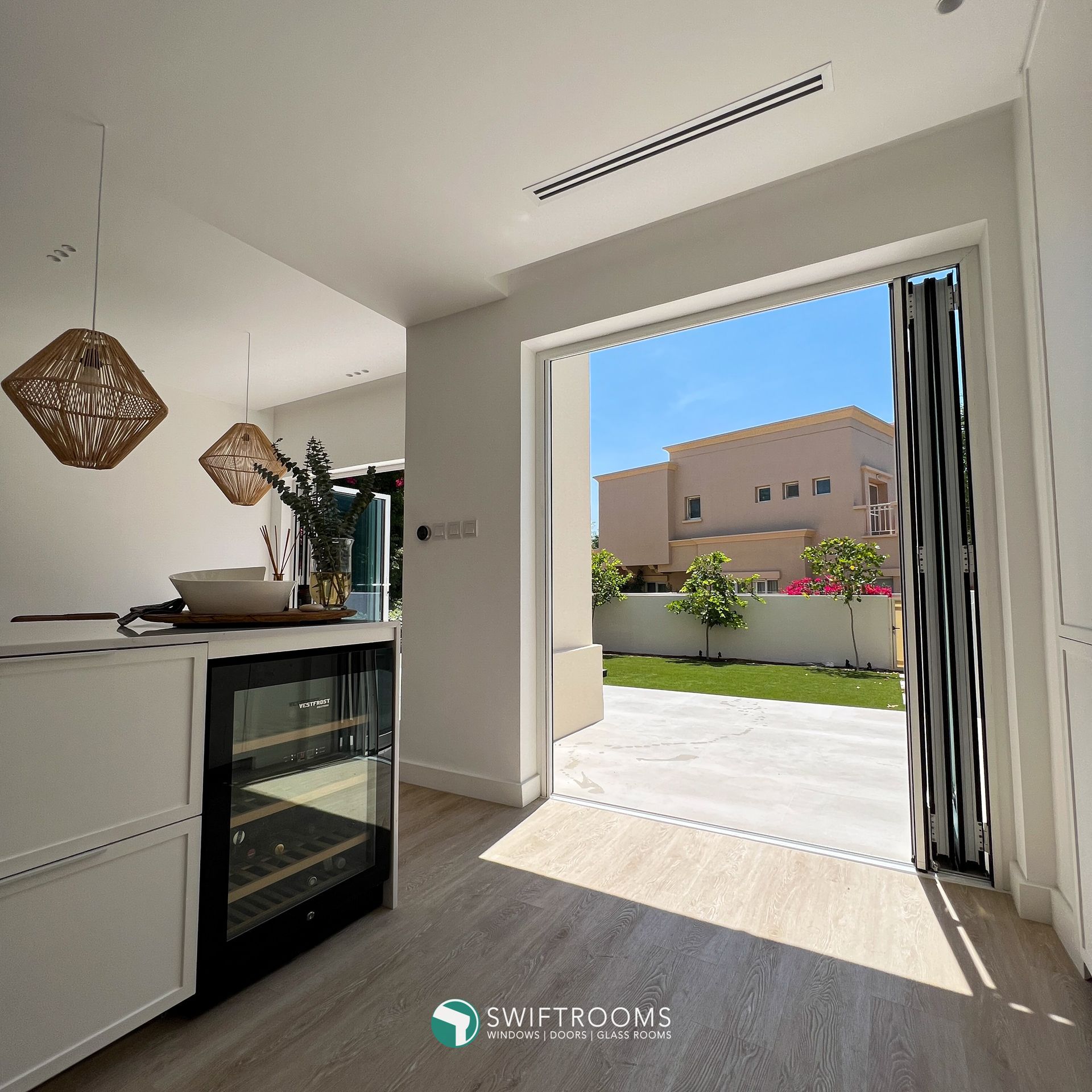 A kitchen with a wine cooler and a sliding glass door