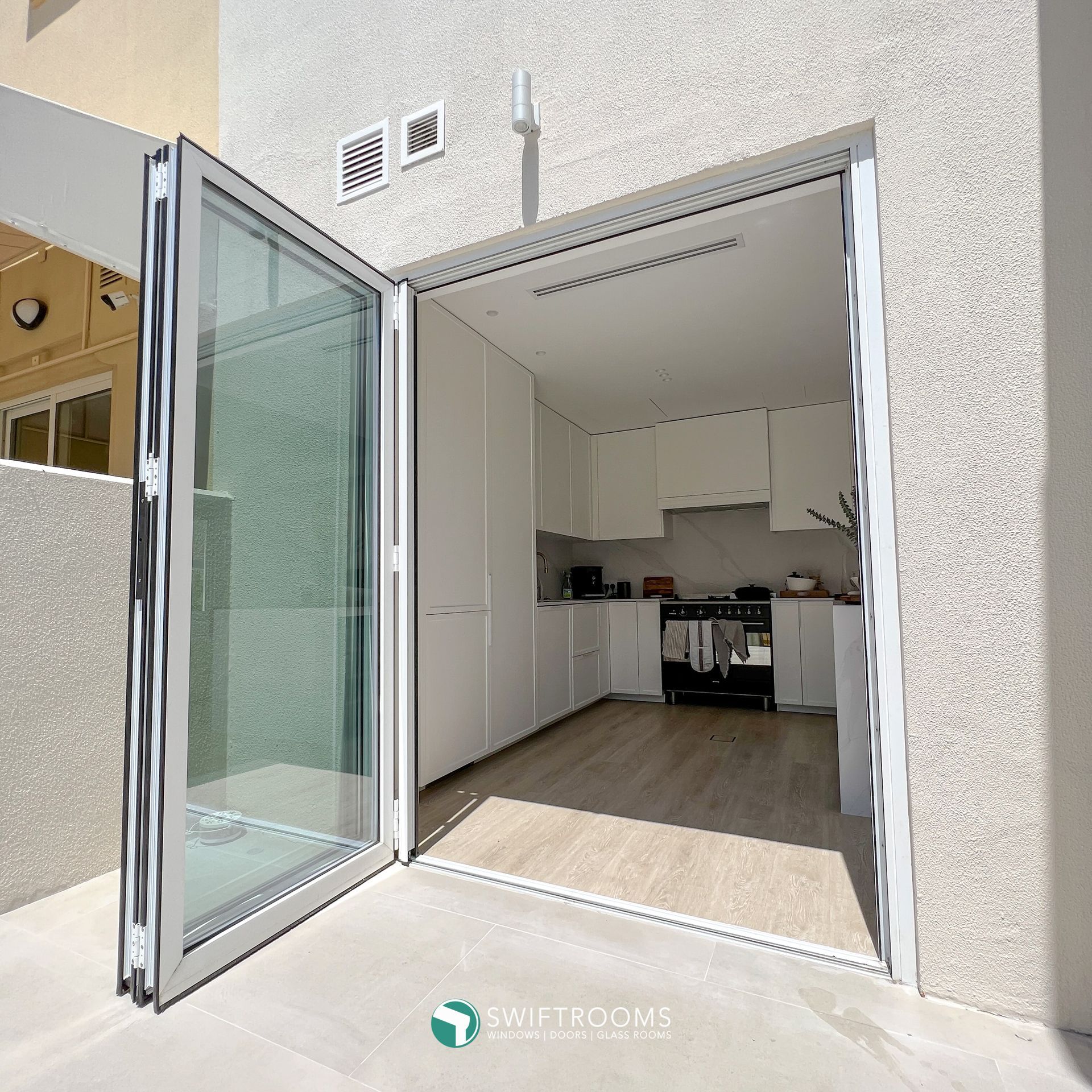 A kitchen with a sliding glass door that is open