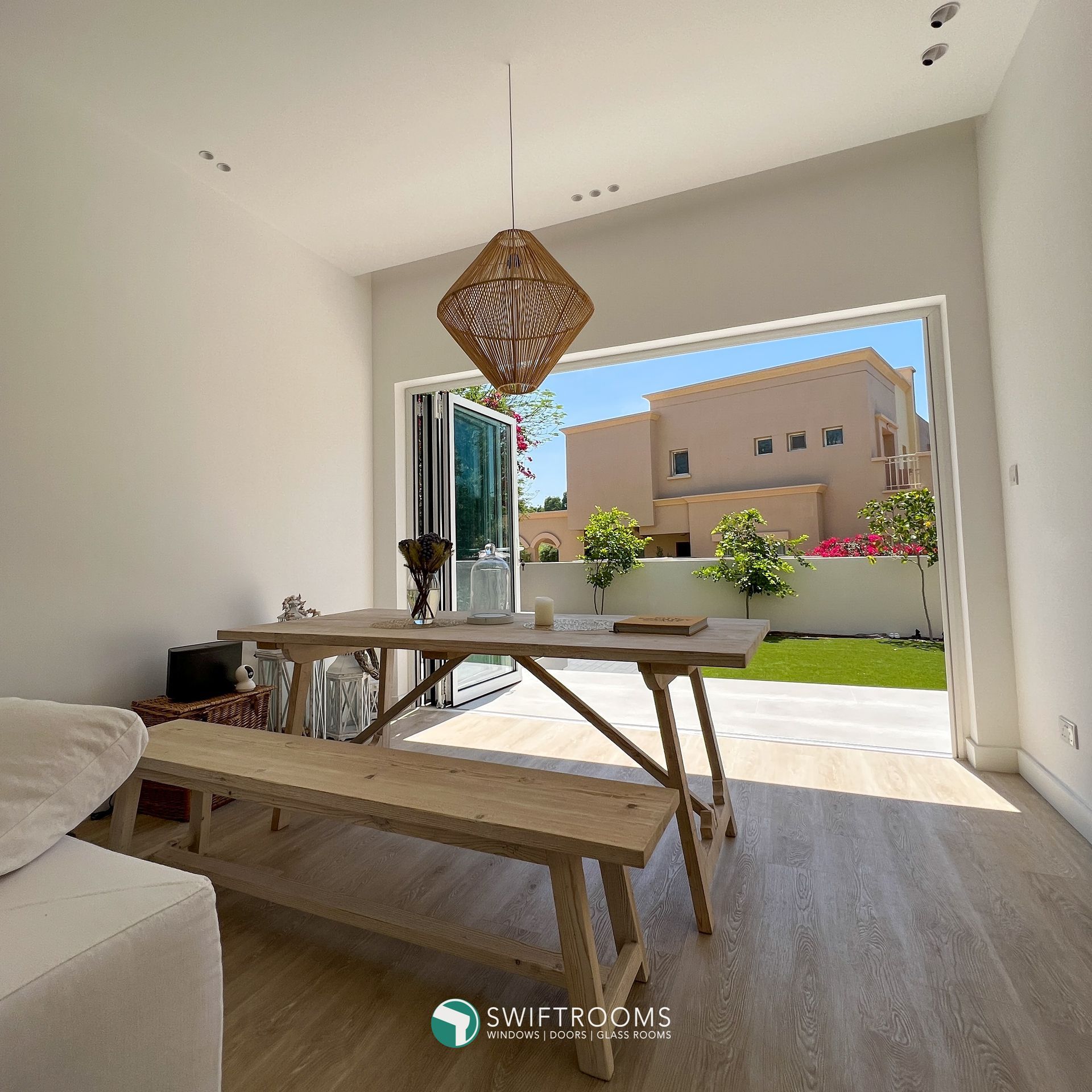 A dining room with a table and bench and a sliding glass door