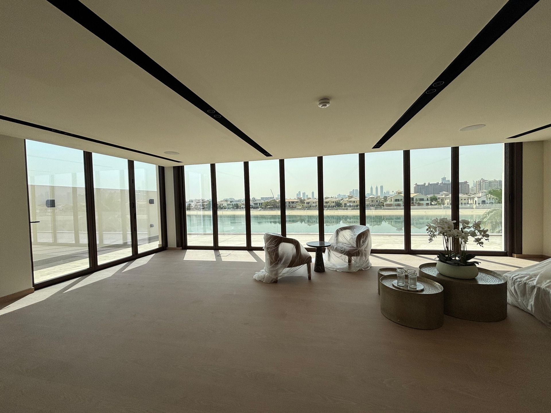 A living room with a lot of windows and chairs