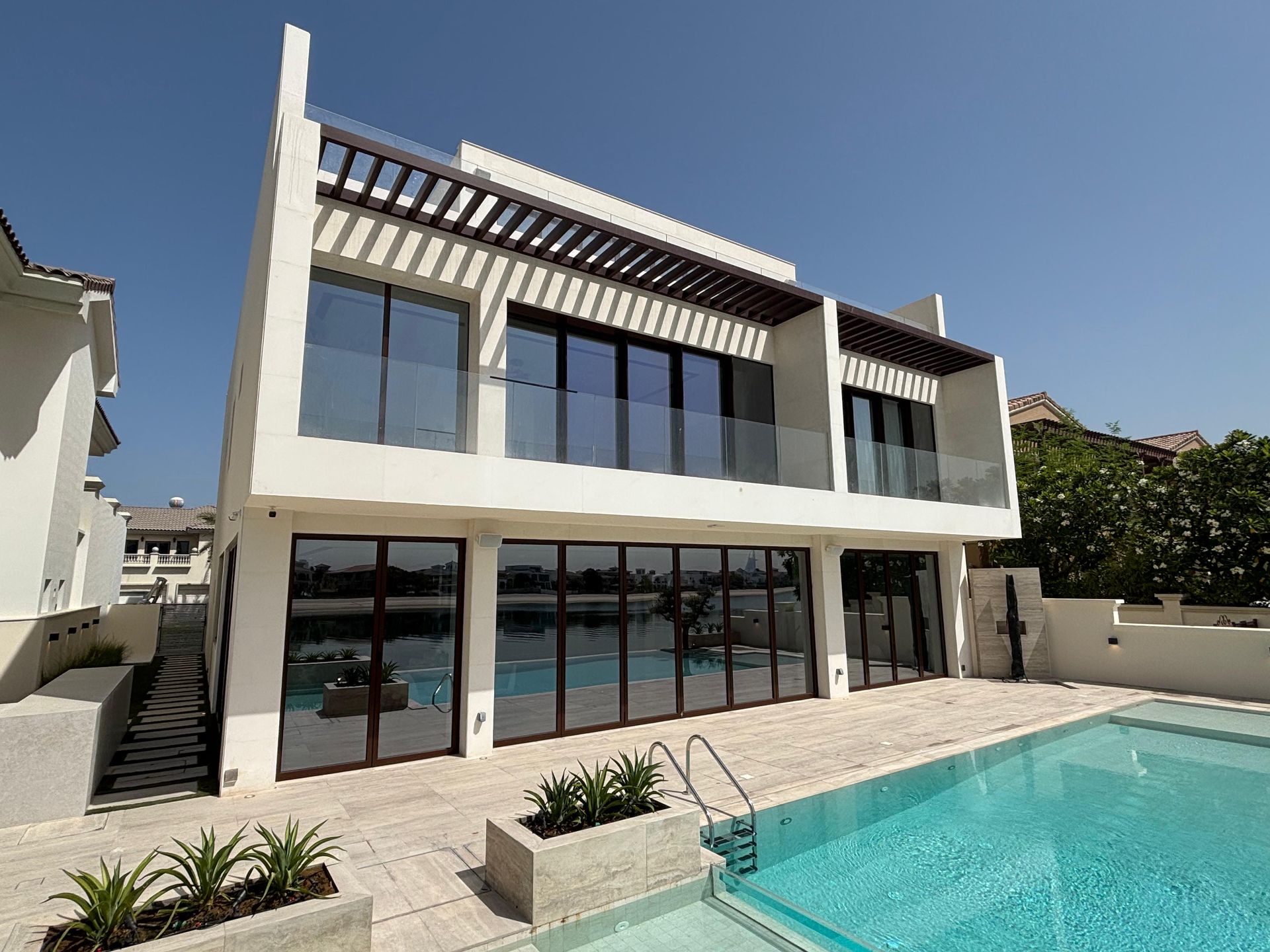 A large white house with a swimming pool in front of it.