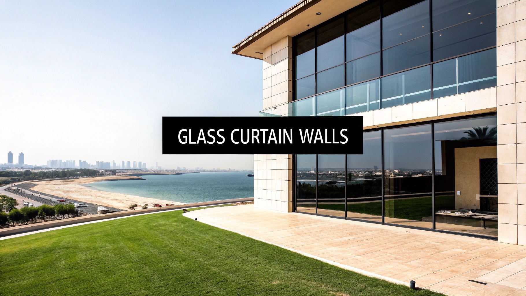 Modern building with glass curtain walls overlooking a beach and city. Text: Glass Curtain Walls.