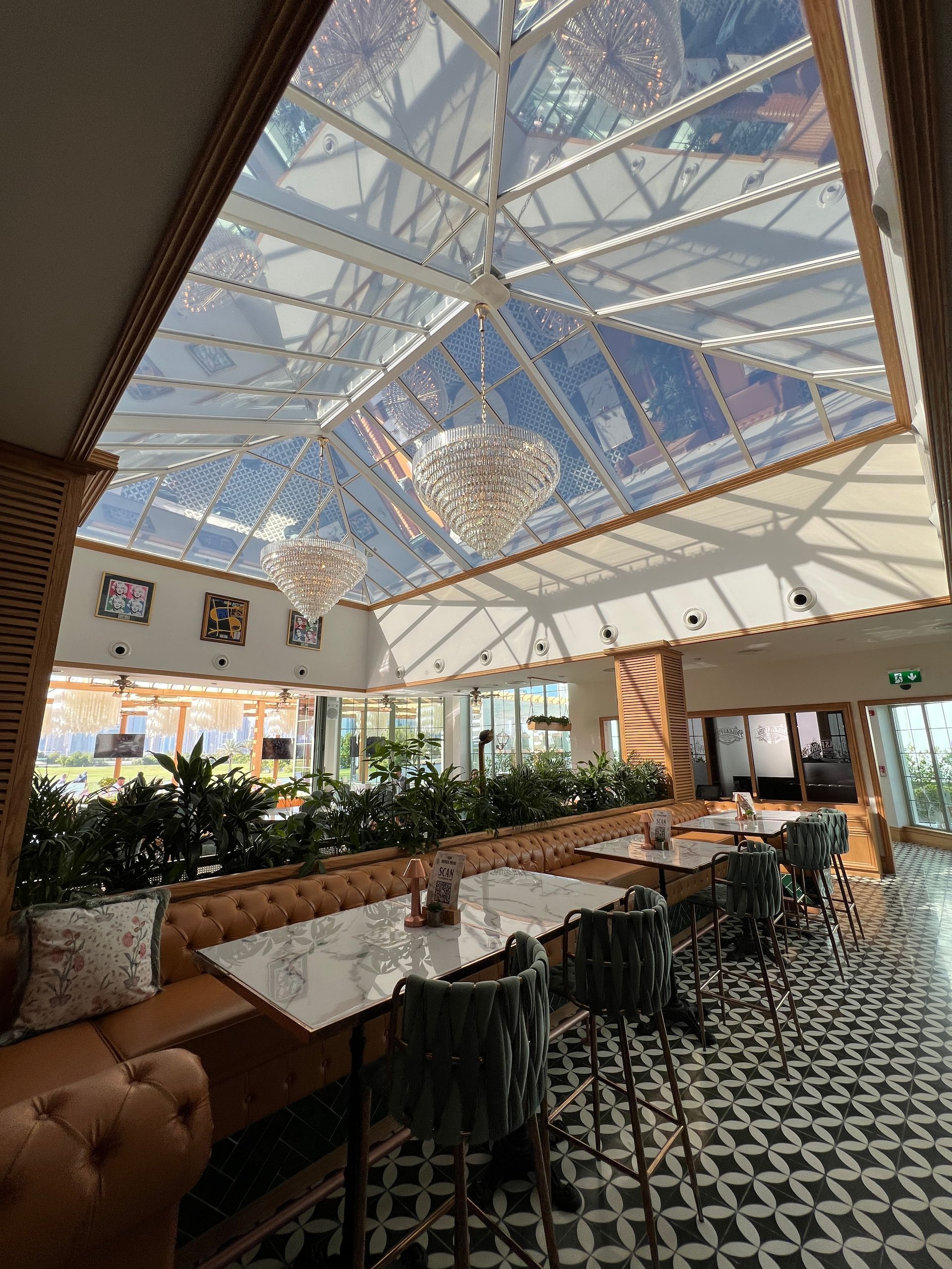 A restaurant with tables and chairs and a clear ceiling.