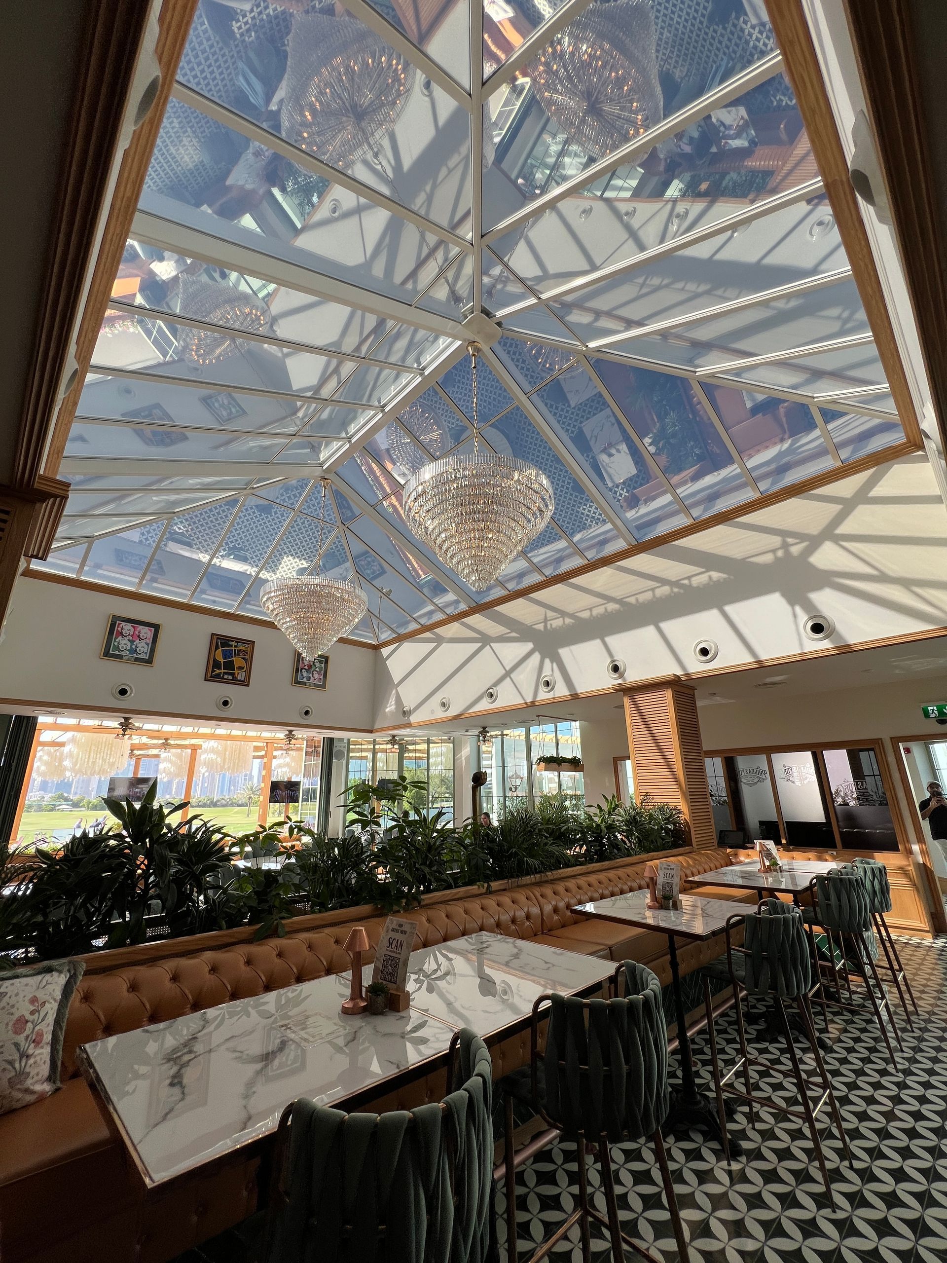 A restaurant with tables and chairs and a clear ceiling.