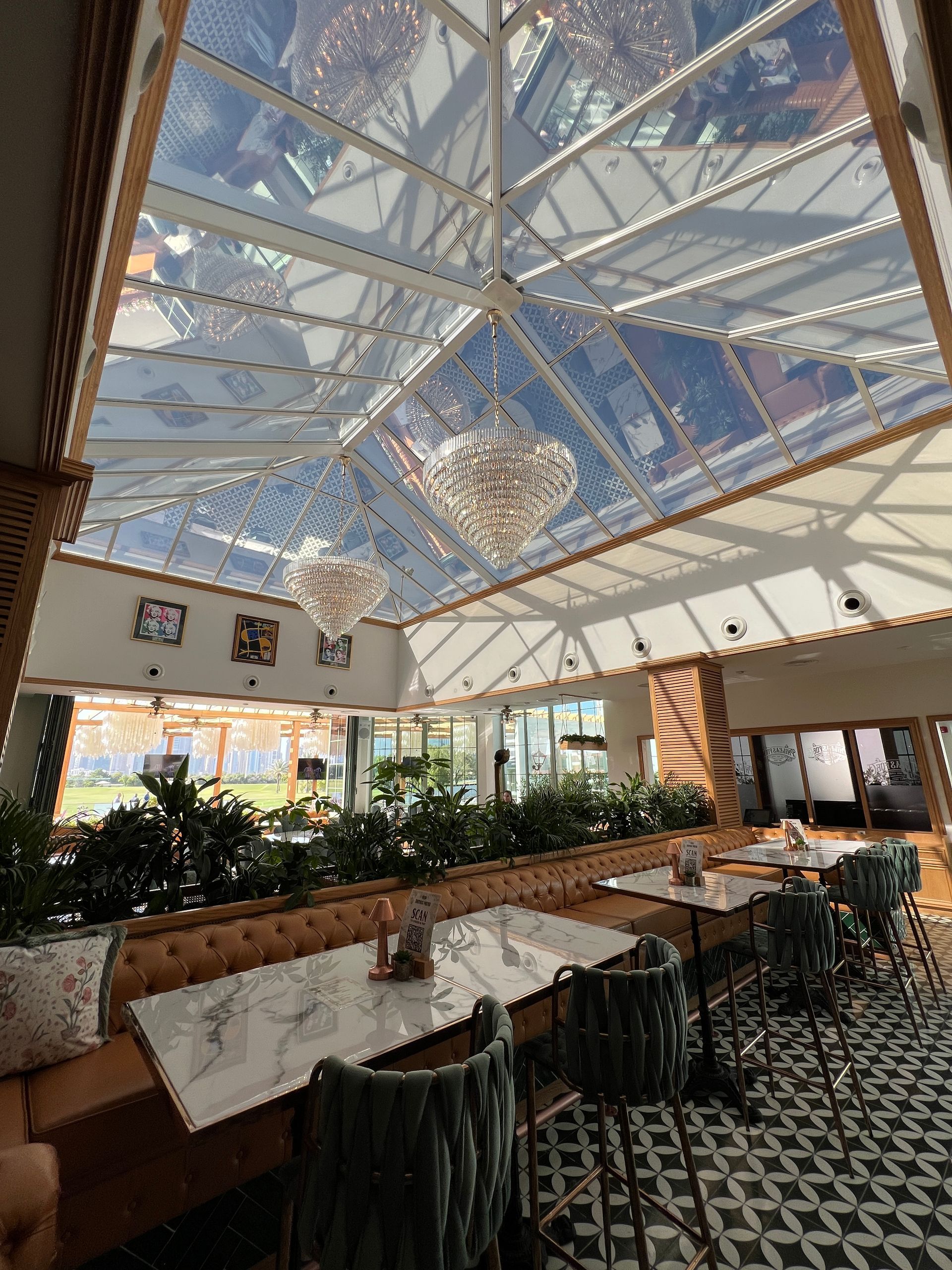 A restaurant with tables and chairs and a clear ceiling.