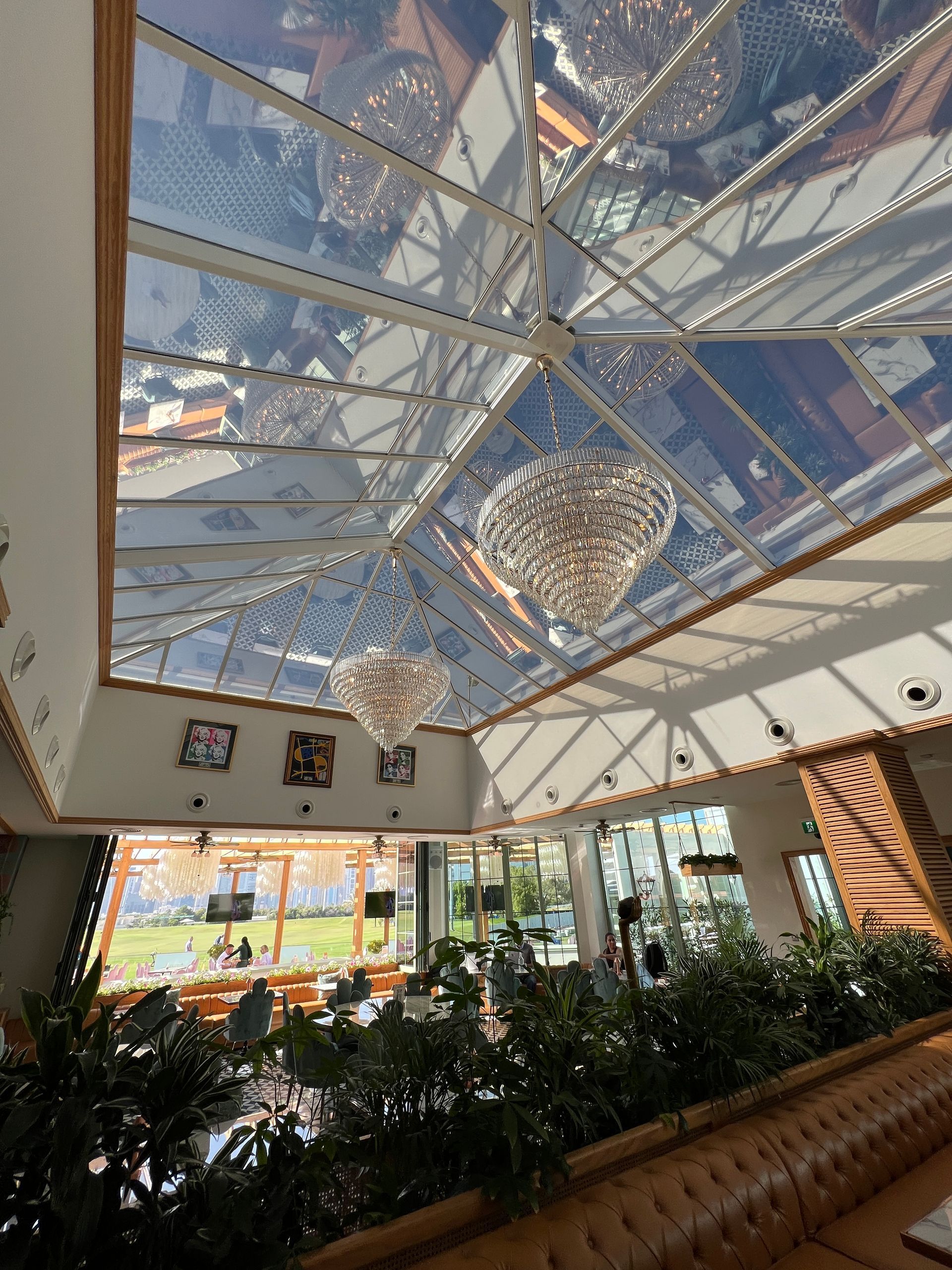 A restaurant with a clear ceiling and a chandelier hanging from it