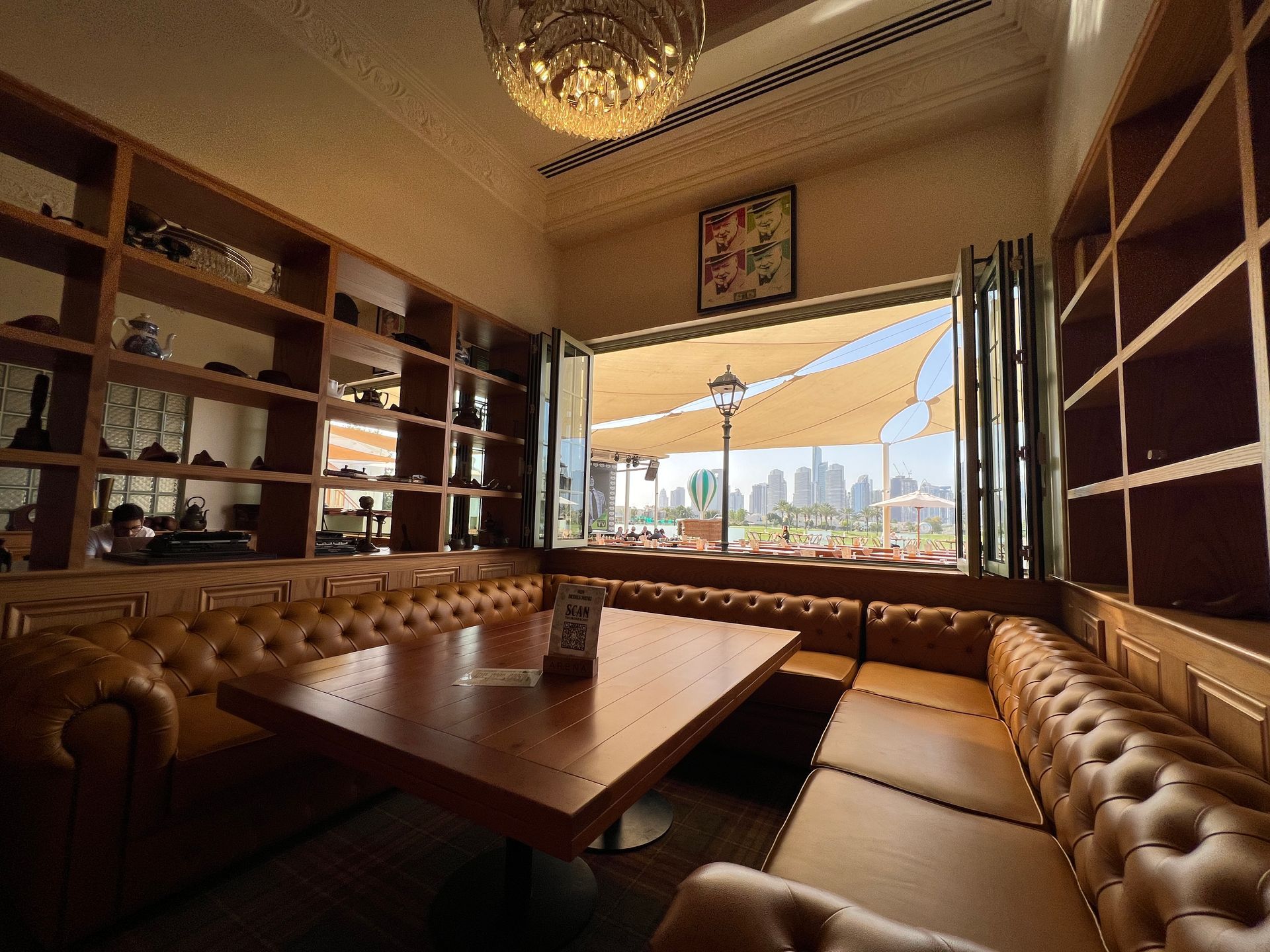 A room with a table and couch in front of a window.