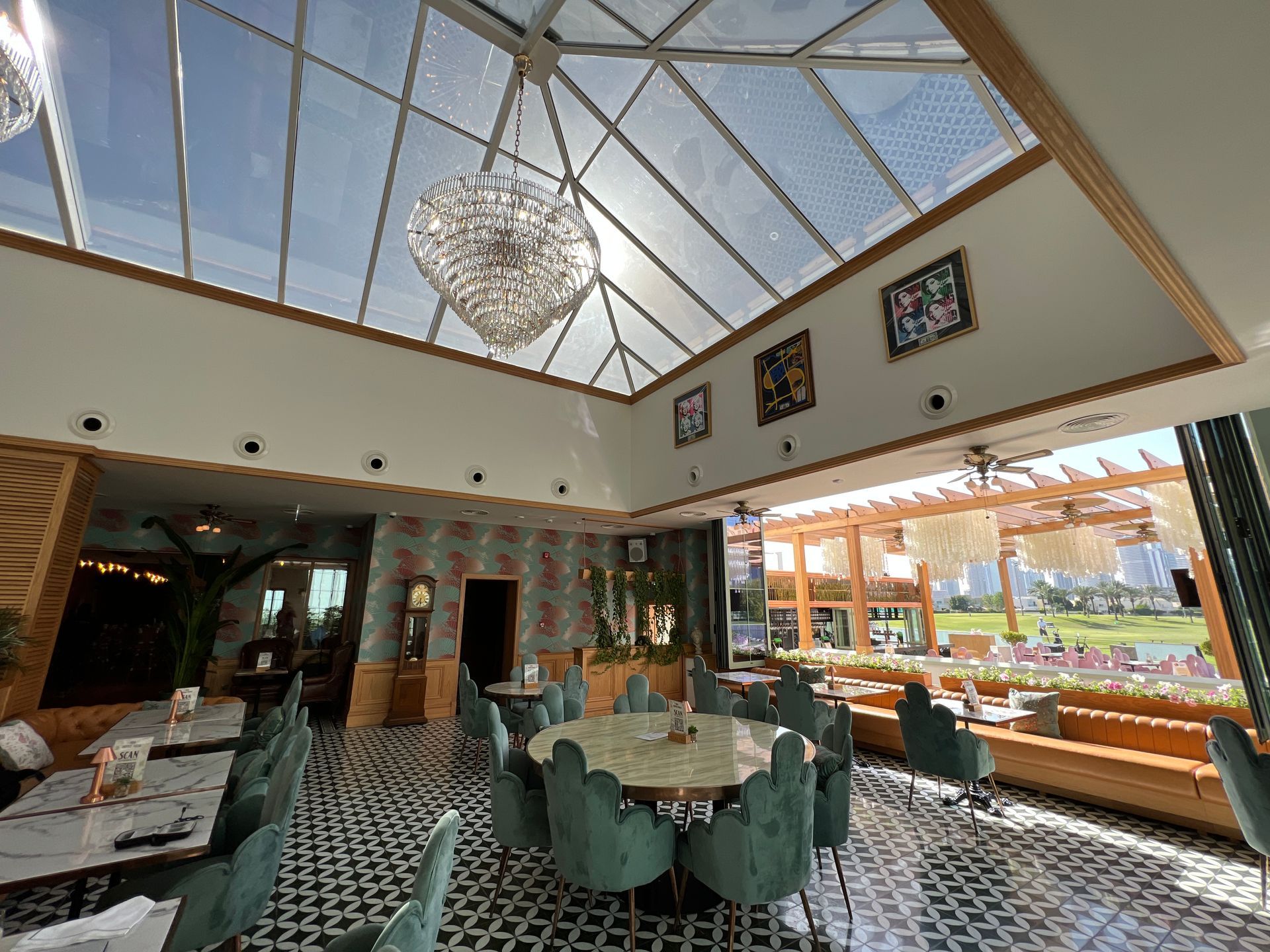 A restaurant with tables and chairs under a glass ceiling.