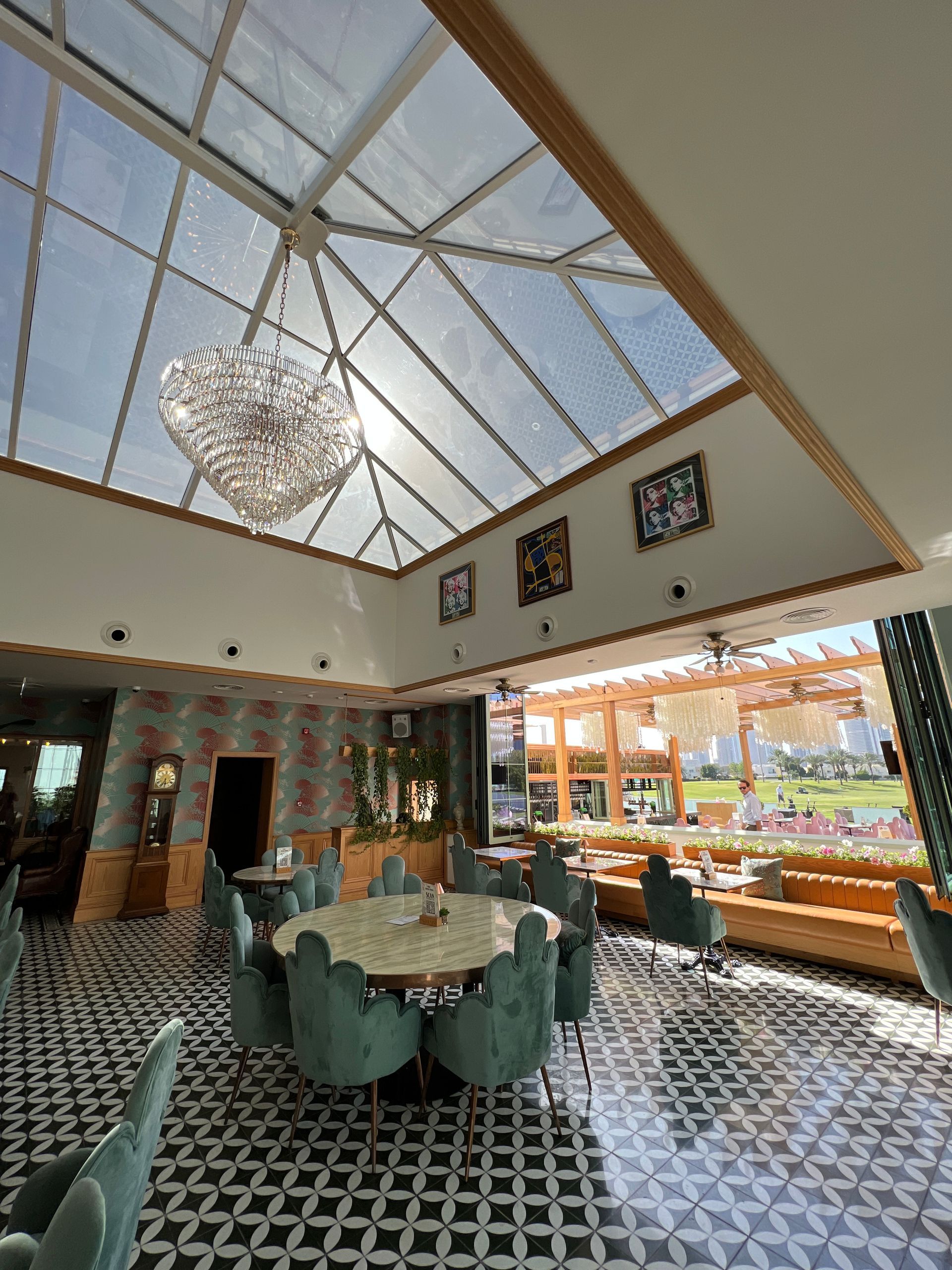 A large room with tables and chairs and a chandelier hanging from the ceiling.
