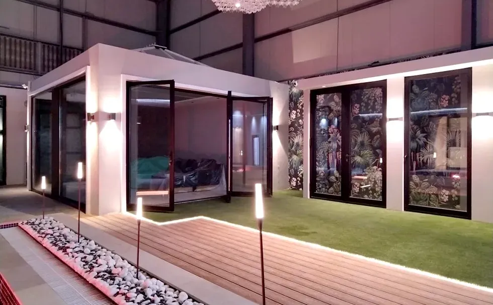 A large room with a lot of windows and a staircase leading to it.