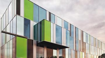 A large building with a lot of windows and a green facade.