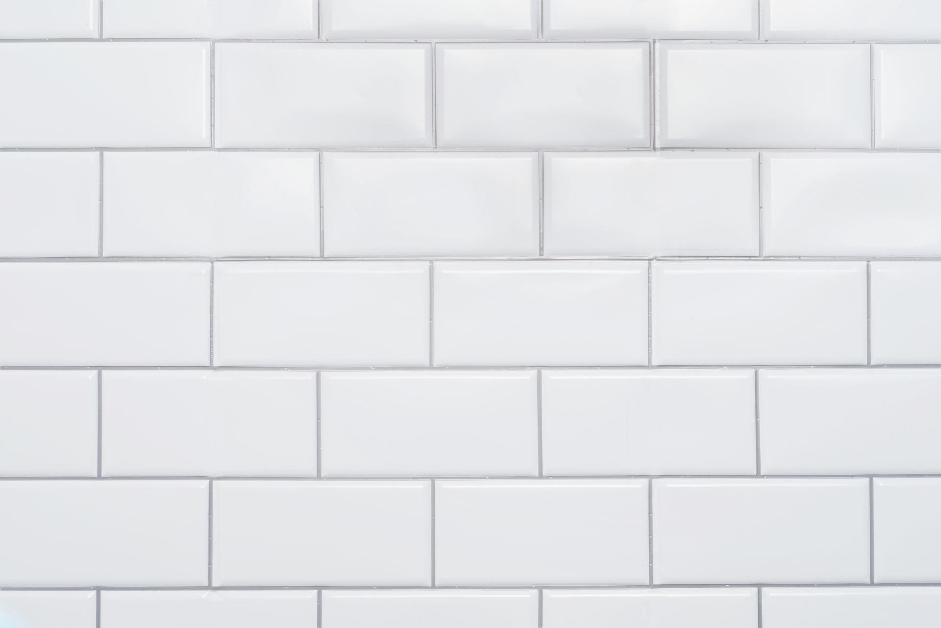White rectangular tile wall with gray grout.