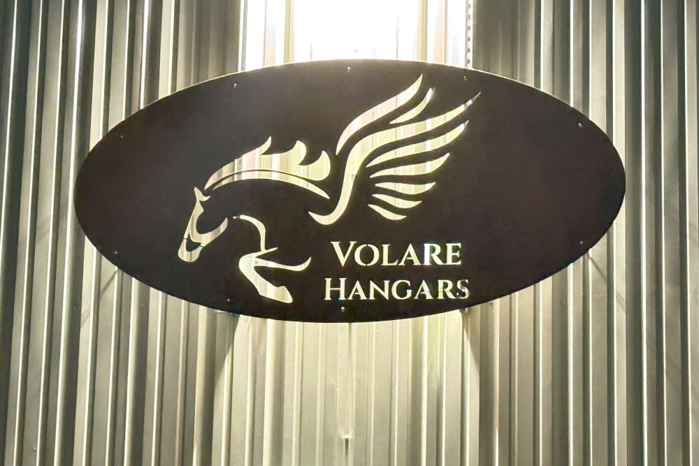 A sign with a horse on it is hanging on a metal wall.