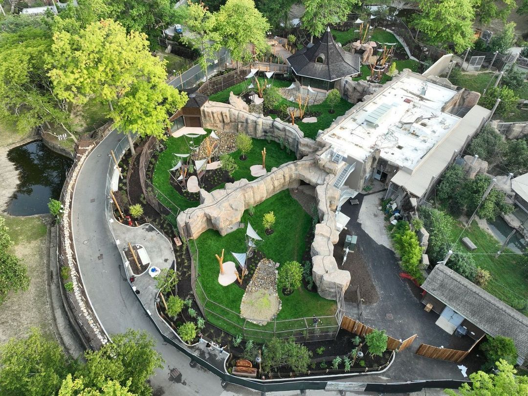 An aerial view of a zoo surrounded by trees and grass.