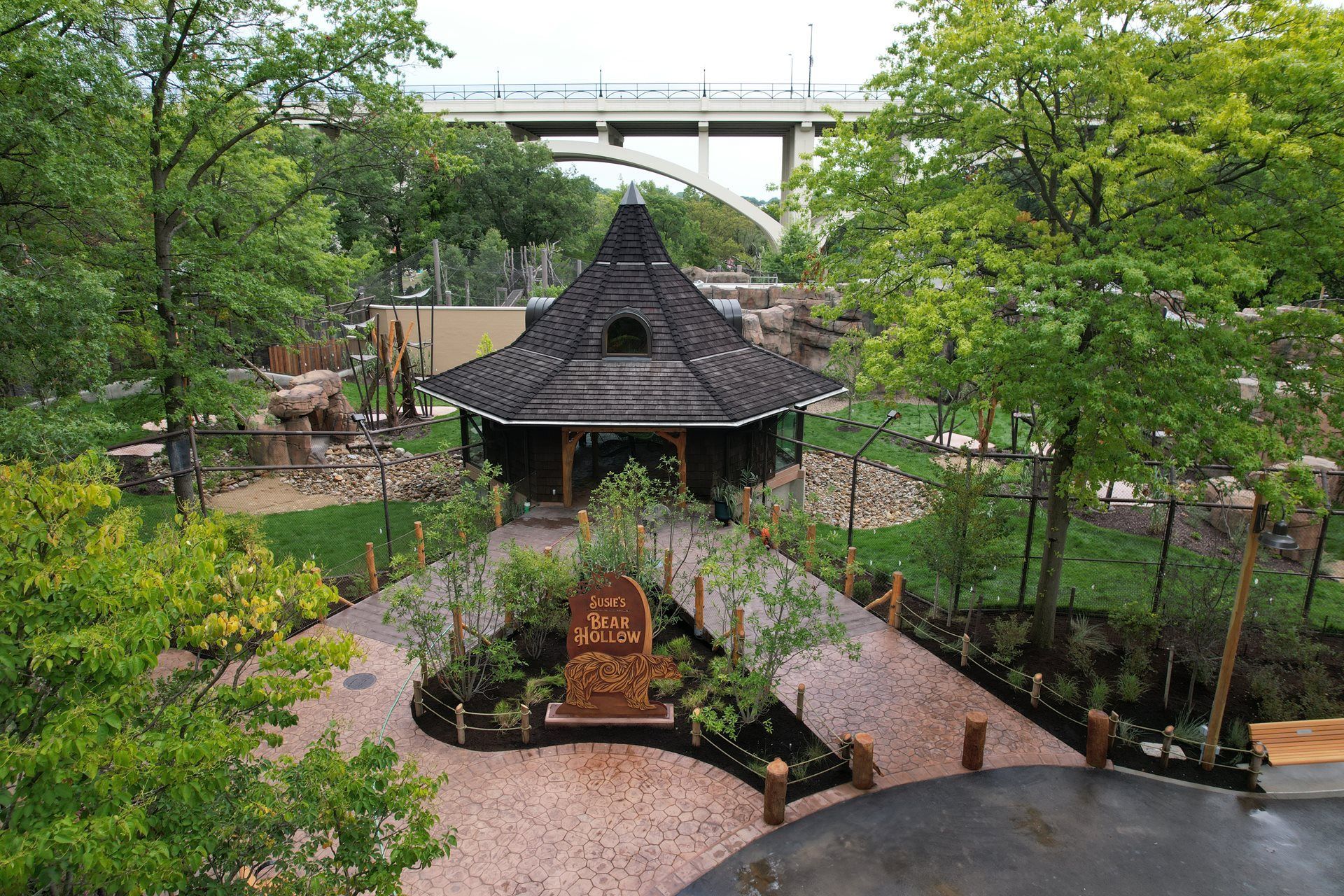 An aerial view of a park with a bridge in the background